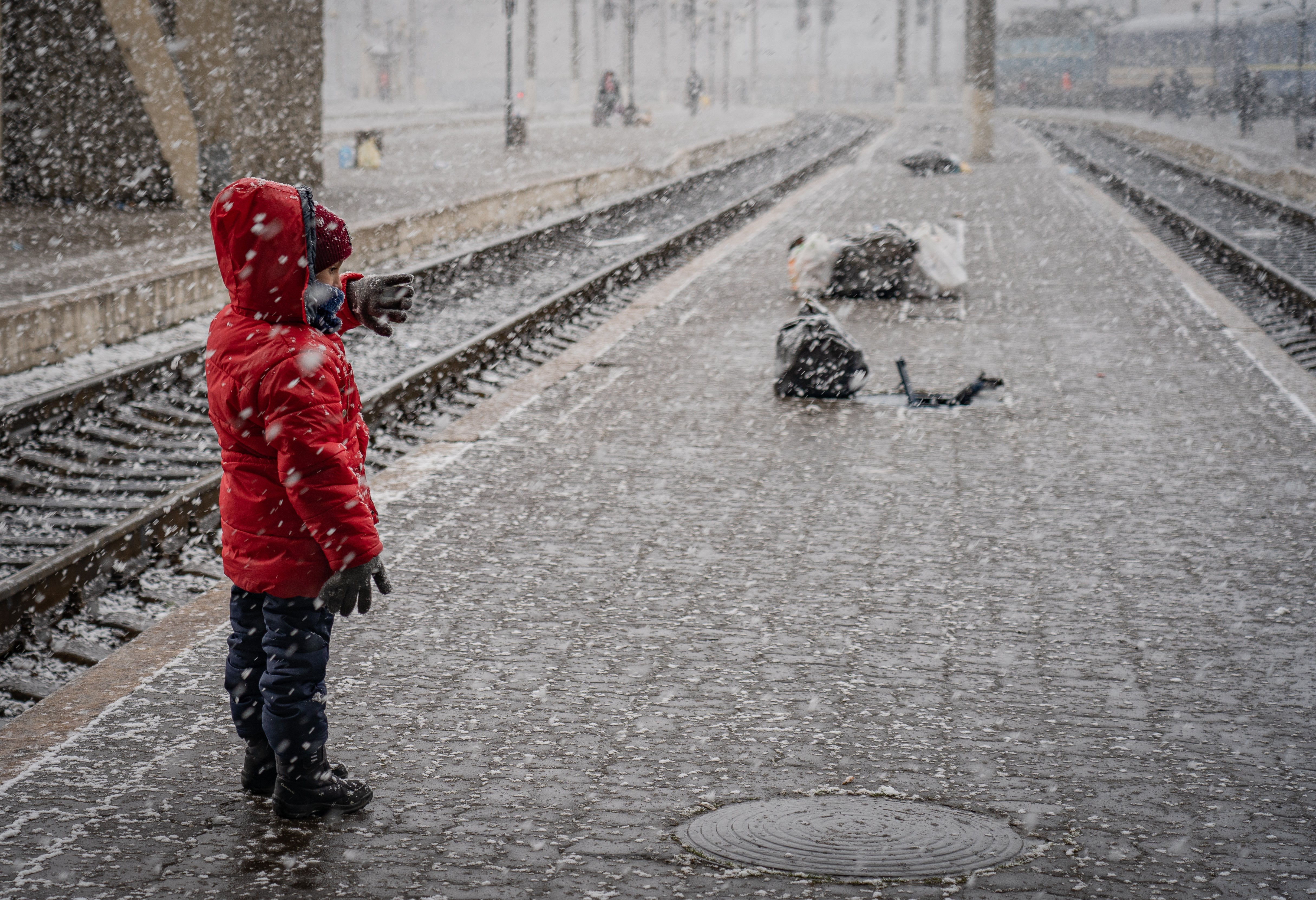 Un niño pequeño del este de Ucrania esperando en la nieve un tren hacia Polonia