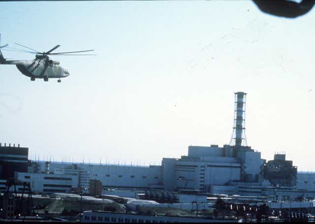 <p>A helicopter flies over the Chernobyl nuclear power plant in Ukraine after the 1986 disaster (PA Archive)</p>