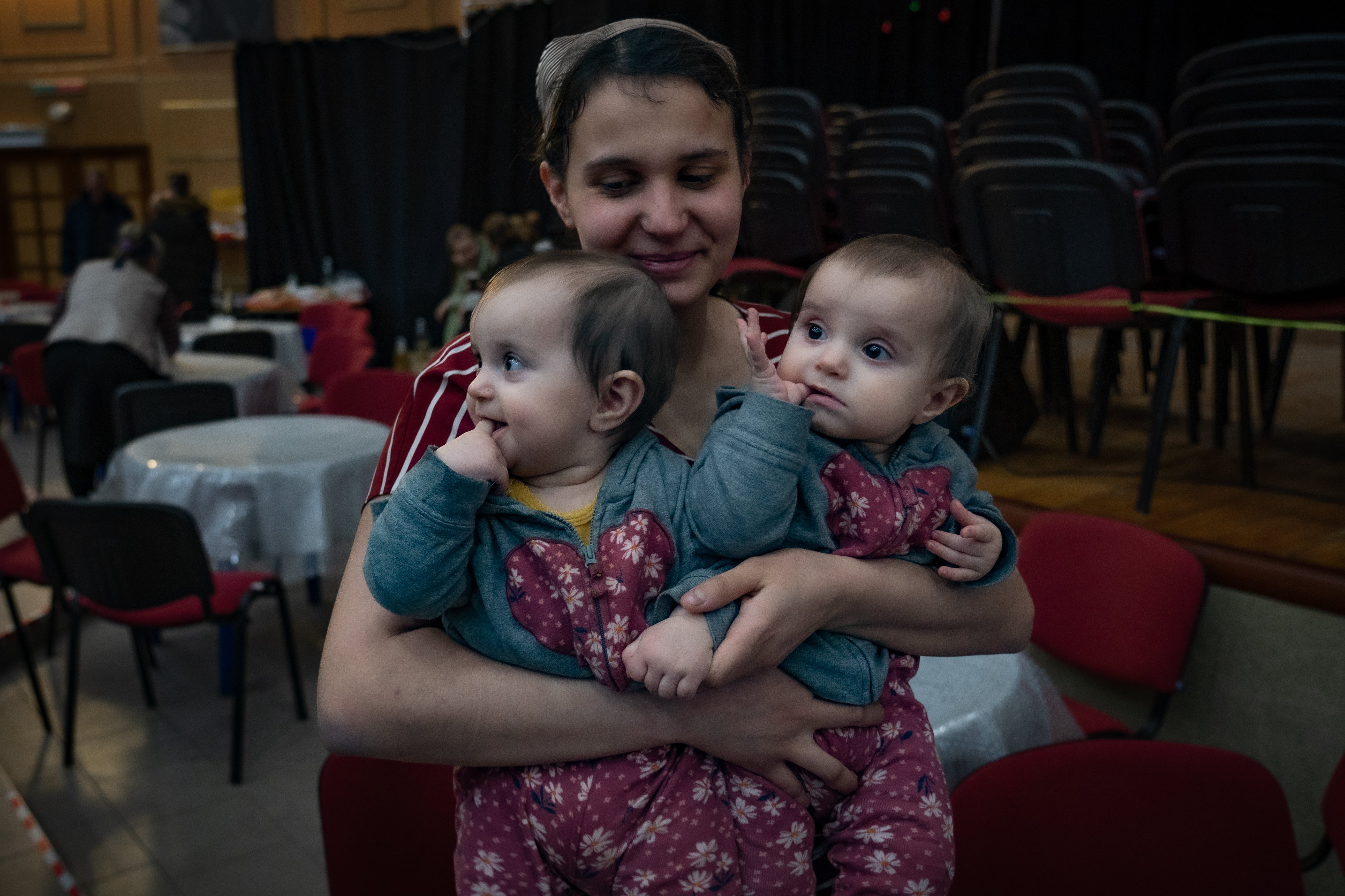 Una mujer carga a sus dos niños pequeños en una iglesia de Khmelnytskyi