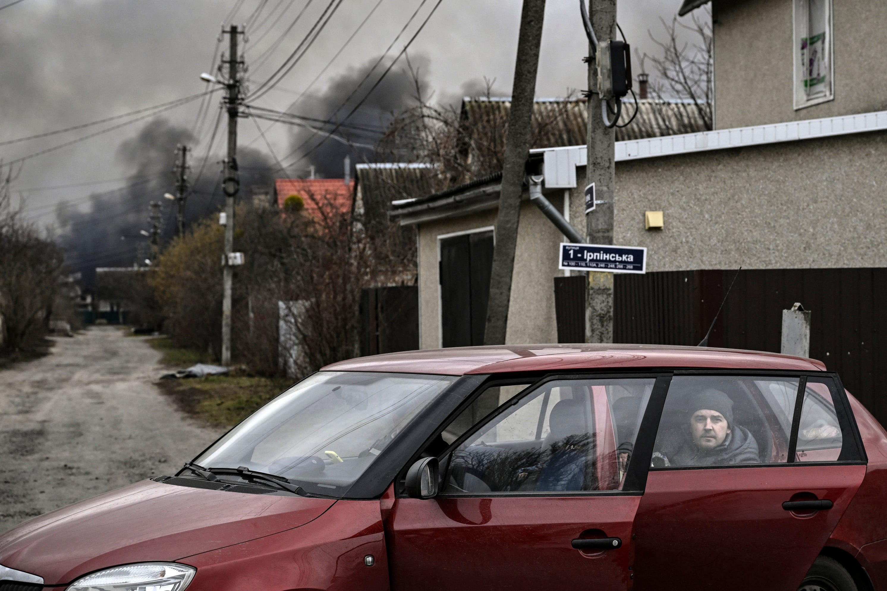 Un hombre observa desde la parte trasera de un auto en la ciudad de Stoianka, al oeste de Kyiv