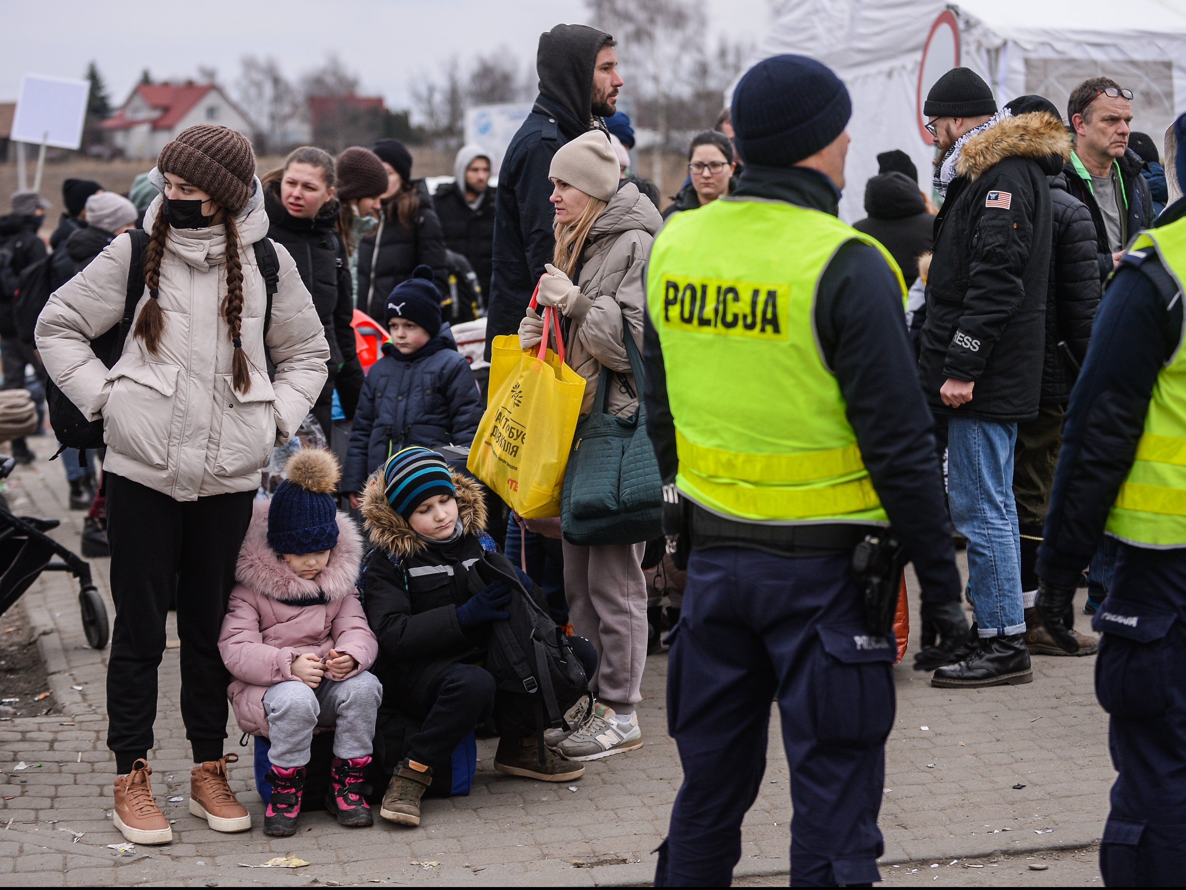Personas que huyeron de la guerra en Ucrania esperan para abordar un autobús en Medyka, Polonia, tras cruzar la frontera entre este país y Ucrania
