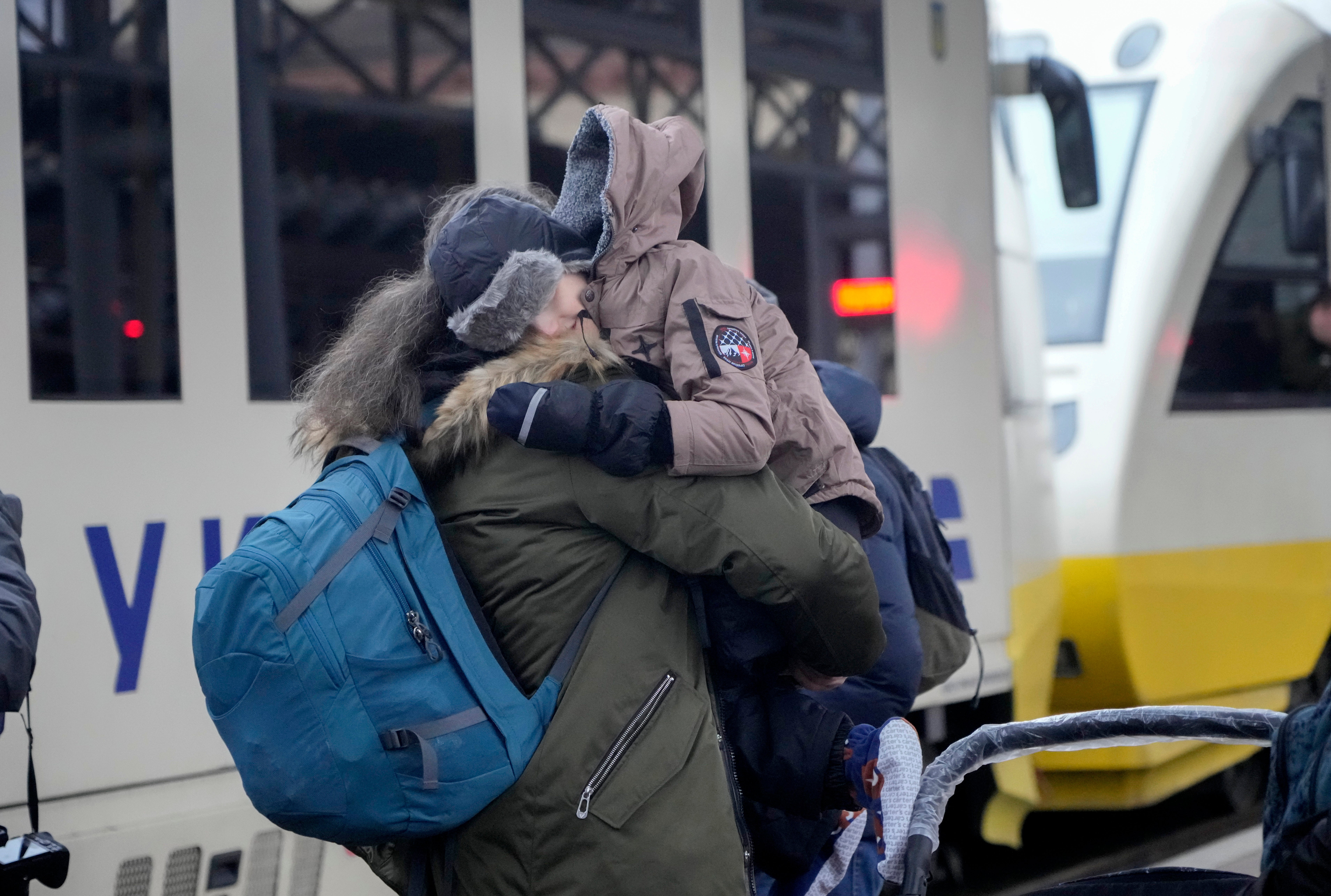 Un niño abraza a su padre antes de subir a un tren tras salir del hospital infantil de Kyiv