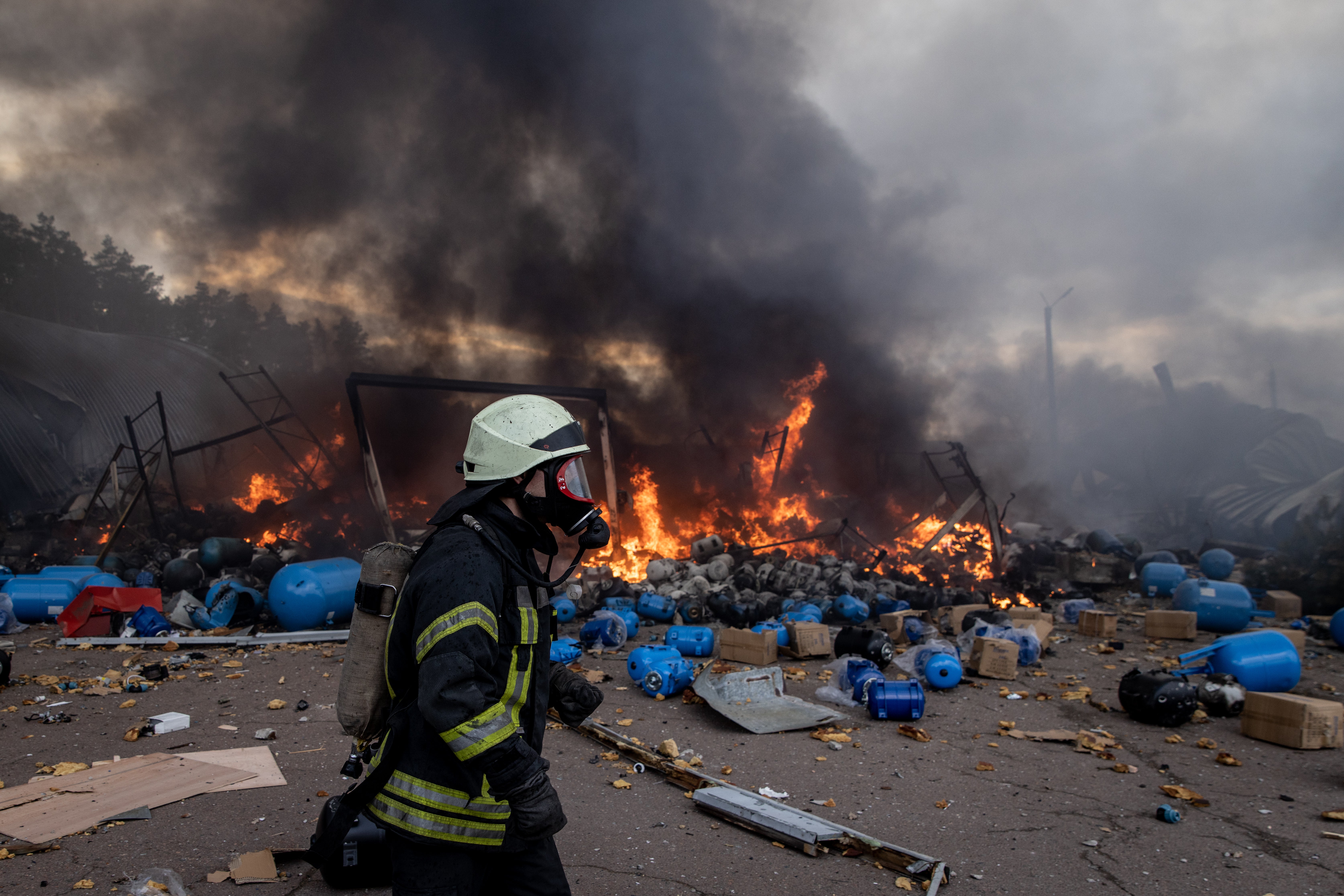 Bomberos tratan de extinguir un incendio después de que a un depósito químico lo impactara un bombardeo ruso en Ucrania