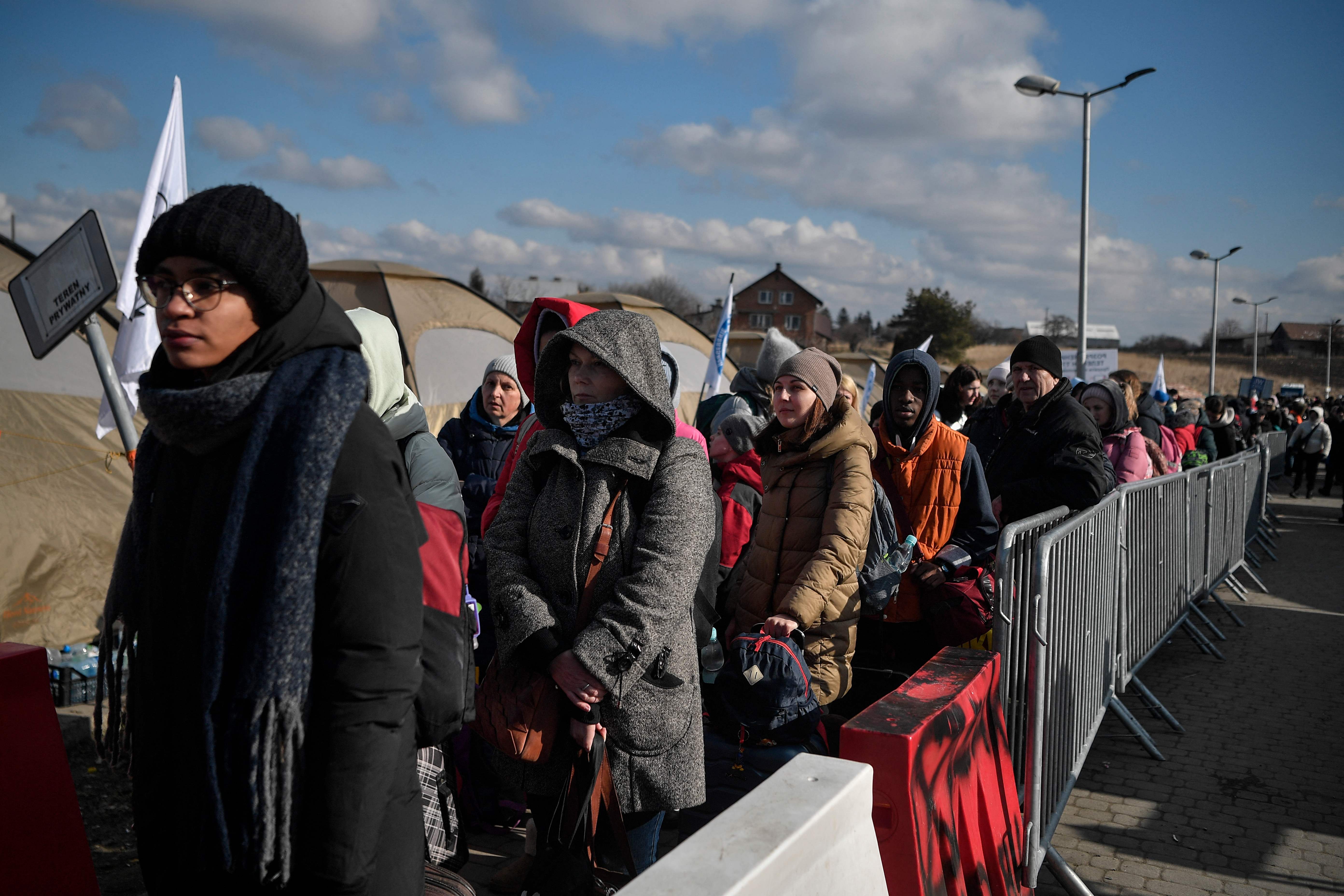Ucranianos esperan a los autobuses fronterizos tras cruzar la frontera con Polonia