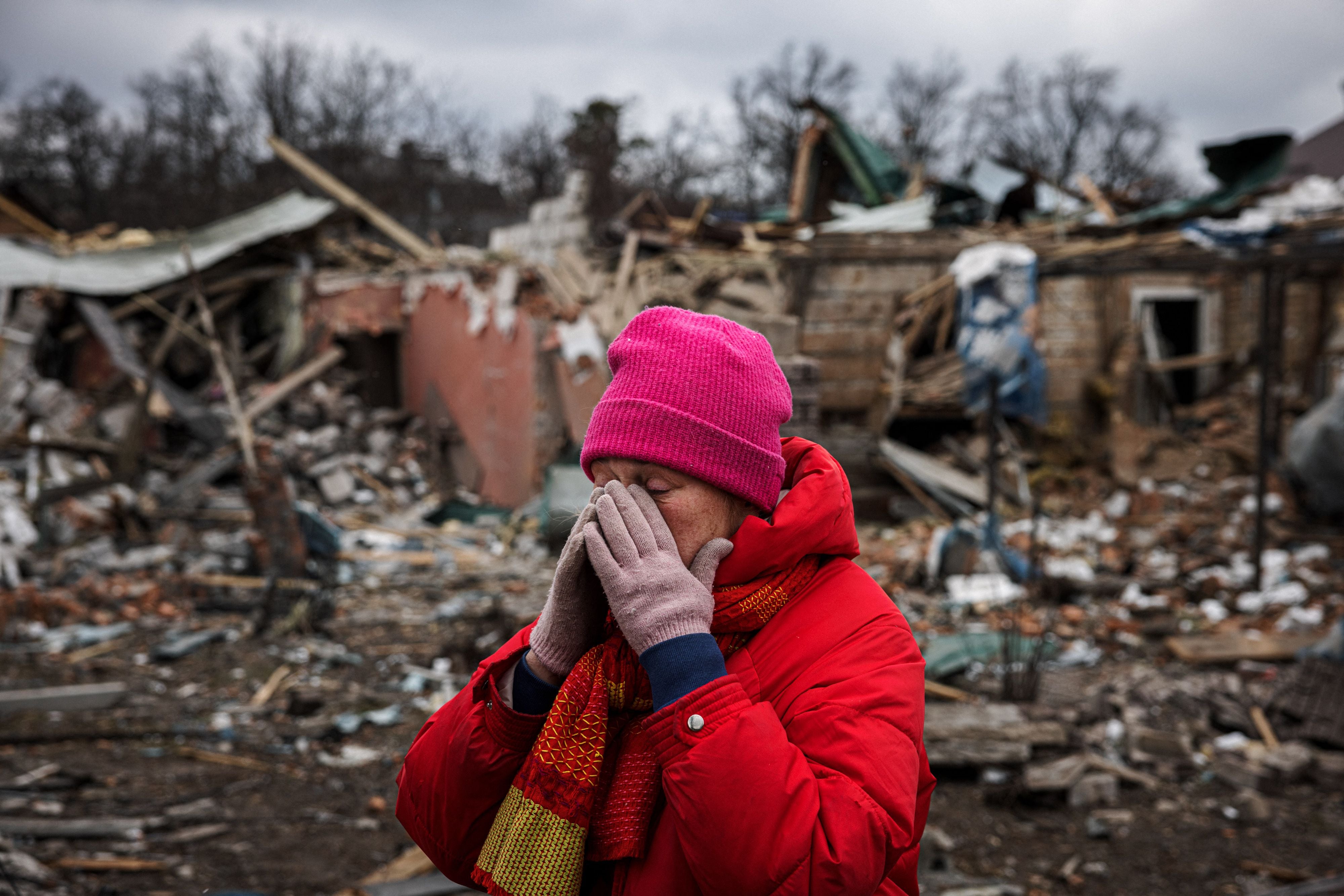 Irina Moprezova, de 54 años, reacciona frente a una vivienda dañada por un bombardeo aéreo en la ciudad de Irpin, al noroeste de Kiev, el 13 de marzo de 2022