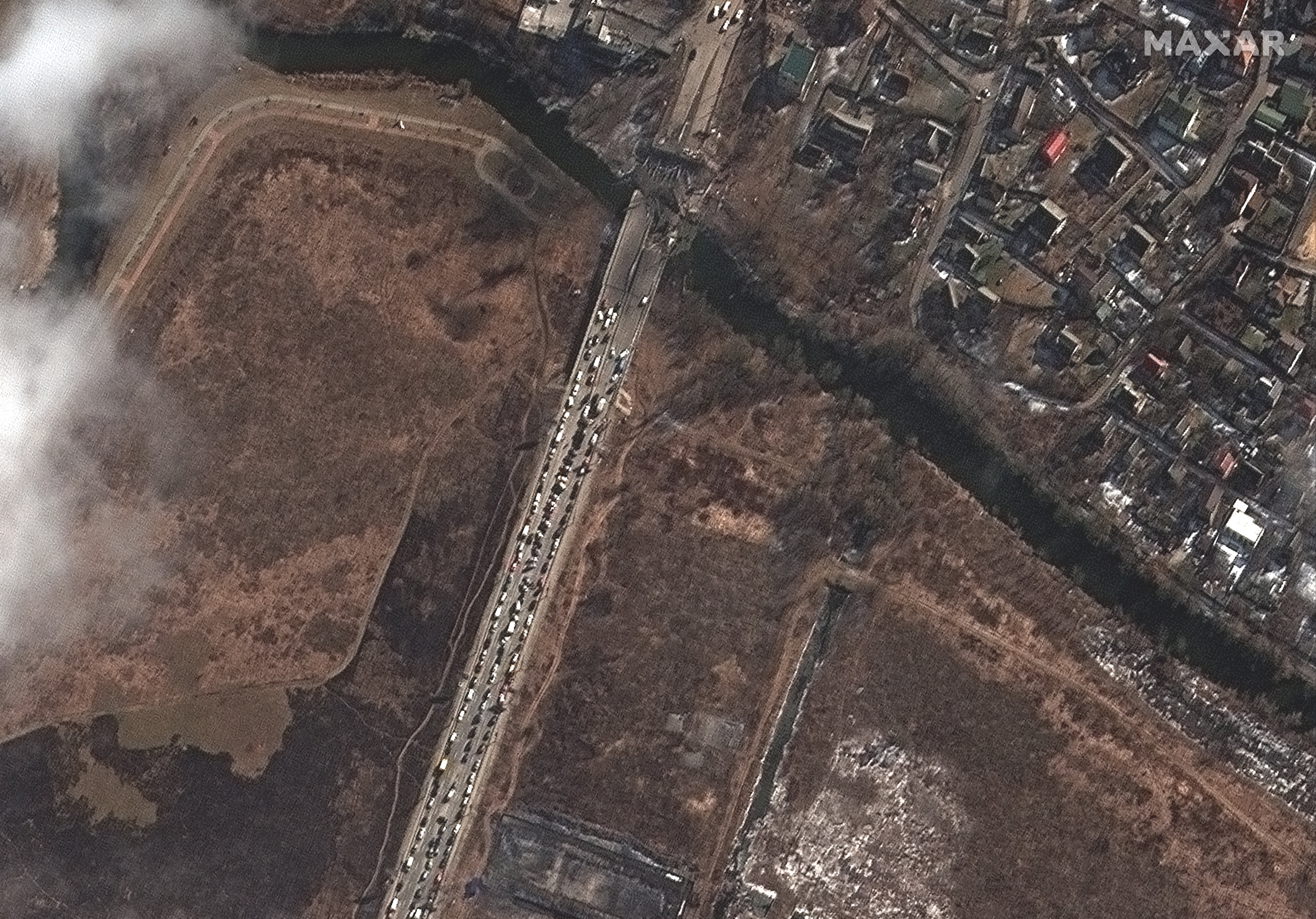 Una imagen satelital del folleto proporcionada por Maxar Technologies muestra personas y automóviles esperando por el puente del río Irpin, Irpin, cerca de Kiev, Ucrania.