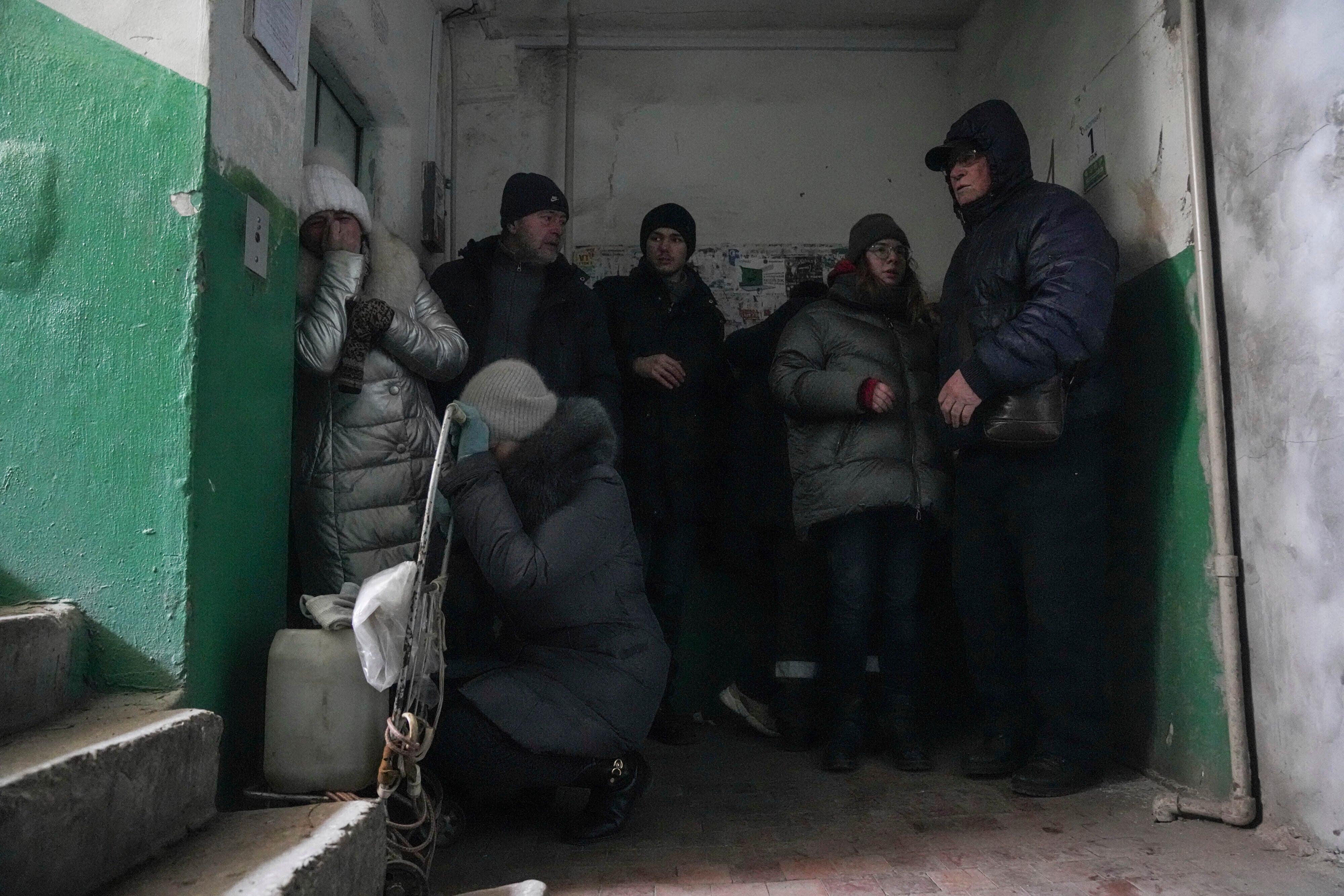 La gente se refugia de los bombardeos en la entrada de un edificio de apartamentos en Mariúpol