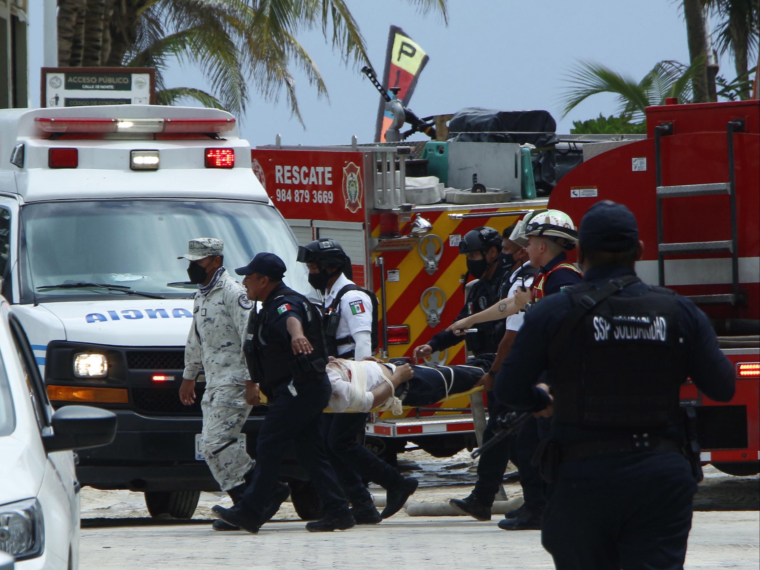 Elementos del ejército mexicano y personal de emergencia y rescate trasladan a una persona lesionada cerca de un restaurante donde se registró una explosión en el área de cocina del club de playa Kool Beach en Playa del Carmen