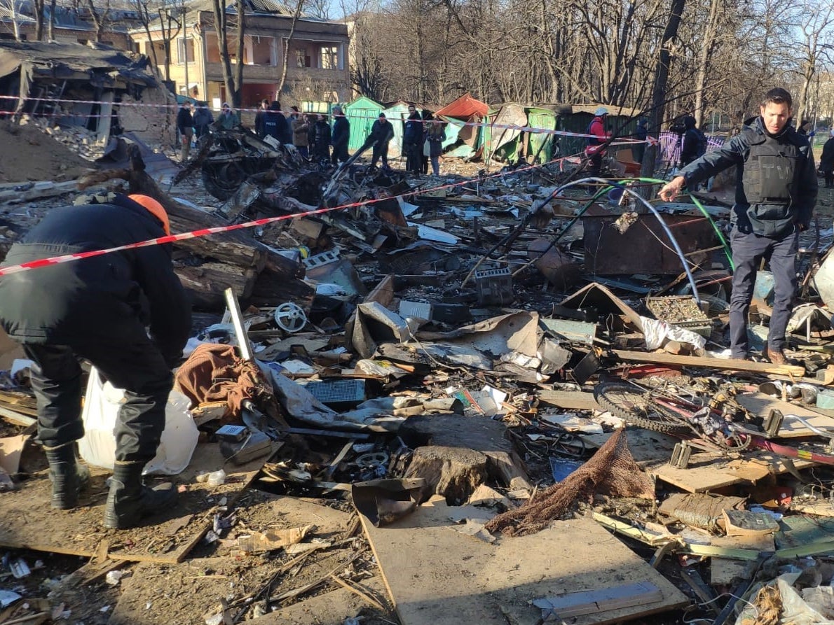 Hombres limpian escombros luego de bombardeos matutinos contra el vecindario de Podil en Kyiv, el 18 de marzo de 2022