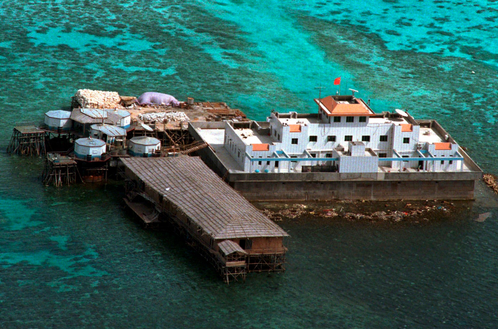 A Chinese flag flies from one of the two newly-finished concrete structures on the Mischief Reef off the disputed Spratlys group of islands in the South China Sea in this aerial photo taken on Monday, 8 Feb. 8, 1999