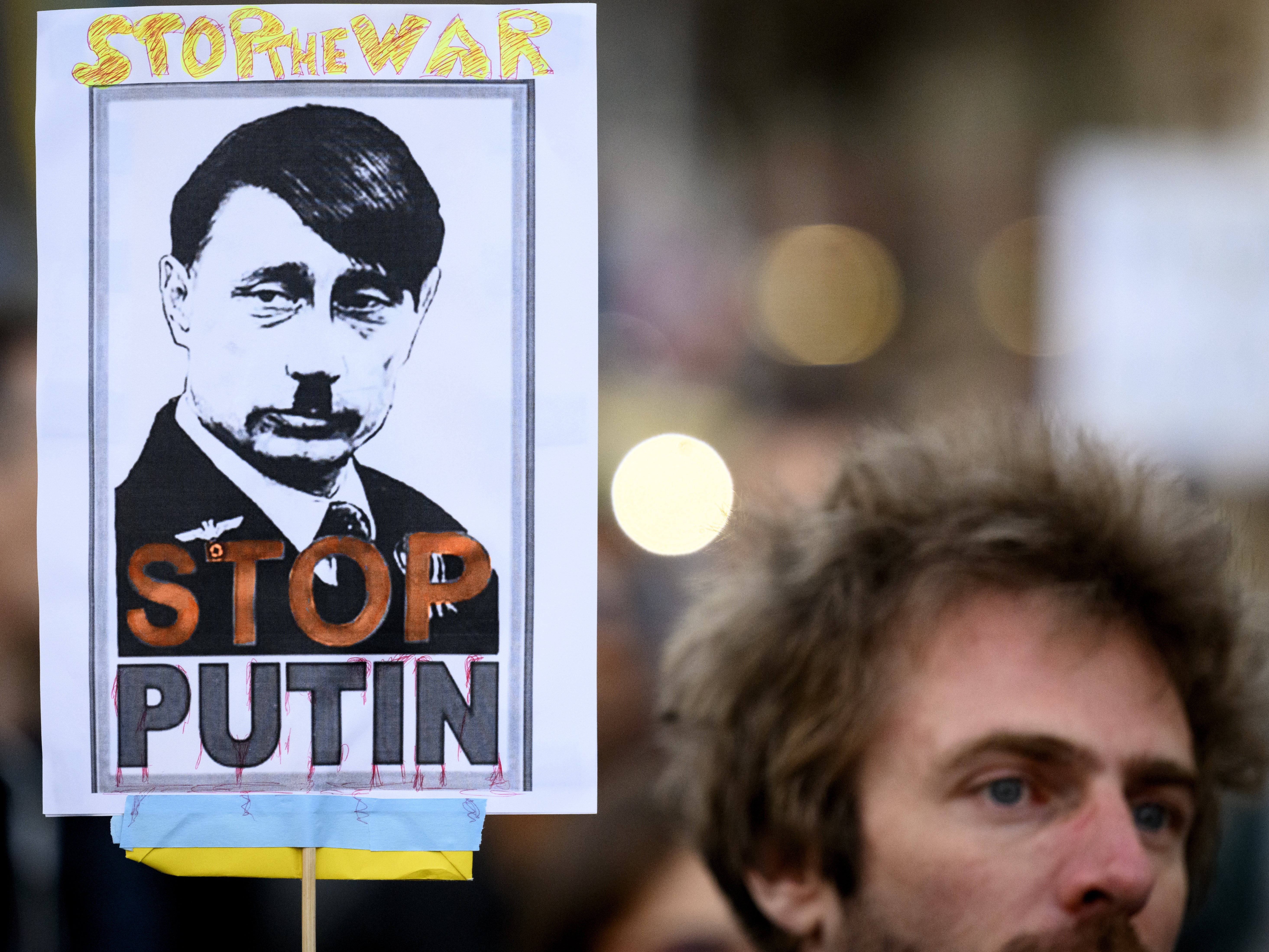Un manifestante sostiene una pancarta que dice “Stop Putin” durante una protesta contra la invasión rusa de Ucrania en Lausanne, Suiza
