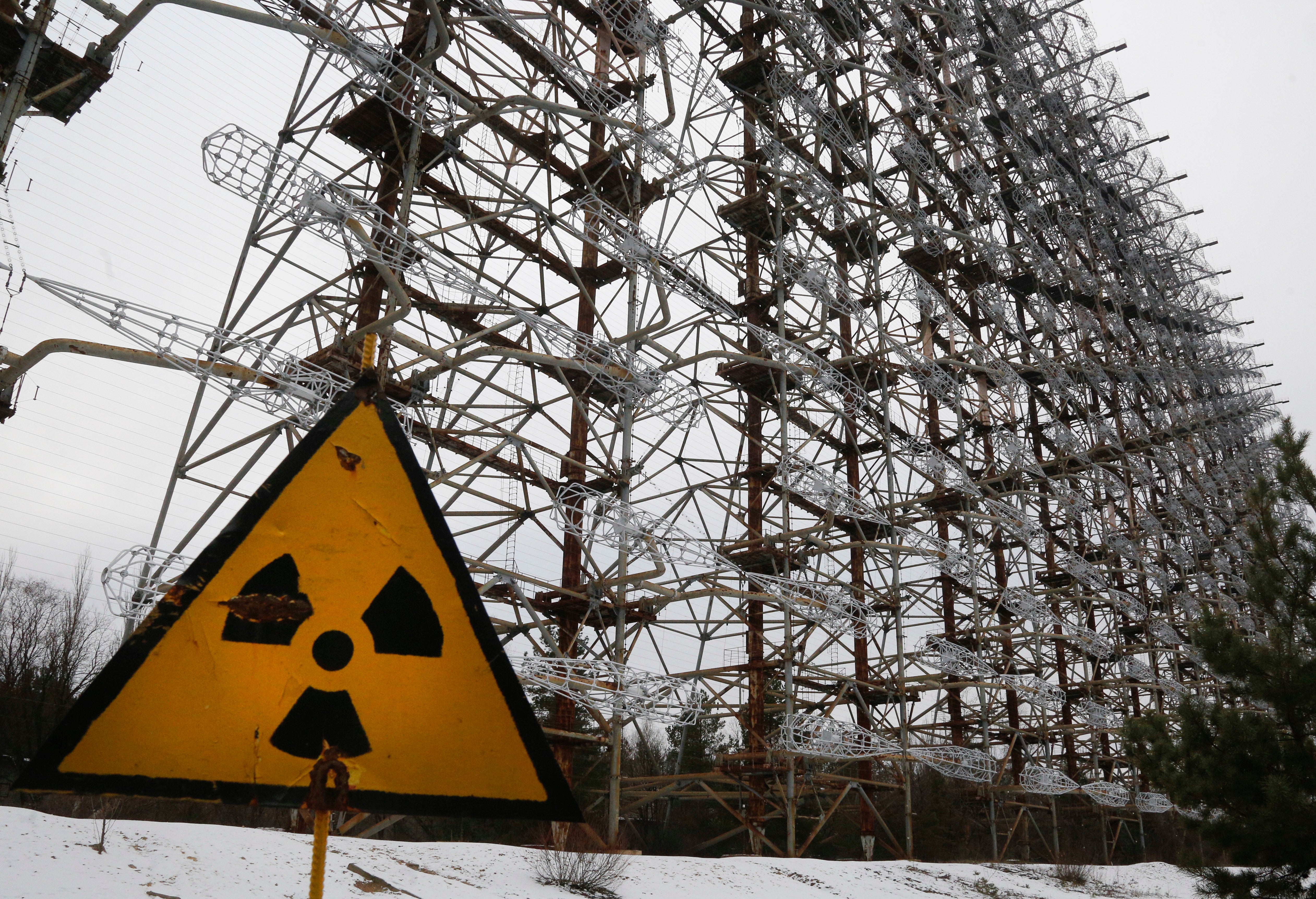 Un sistema de radar de la era soviética detrás de un letrero de radiactividad en Chernóbil