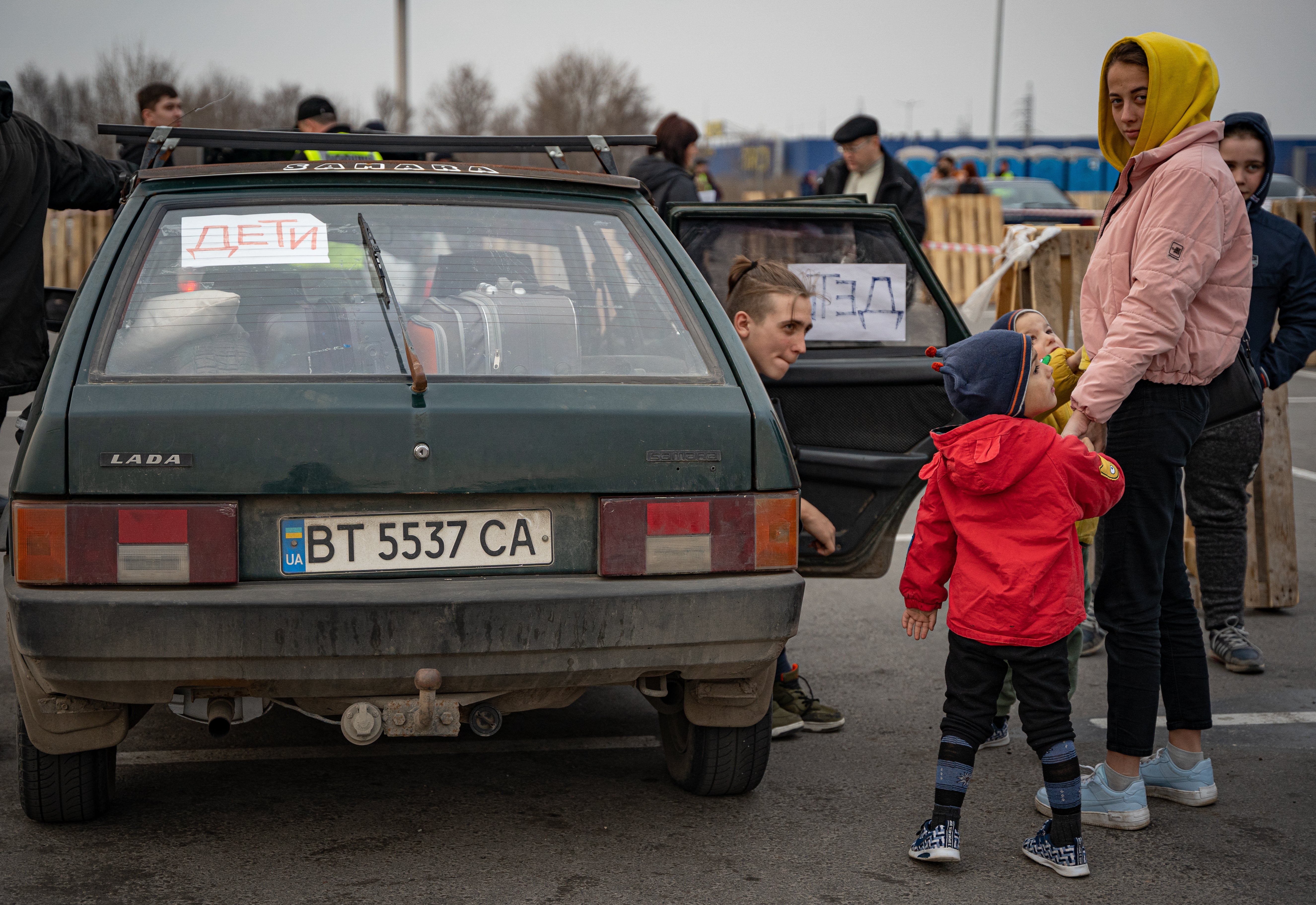 “Niños” está escrito en ruso en una pancarta dentro de un auto que una familia acaba de usar para huir de Mariúpol bajo los bombardeos