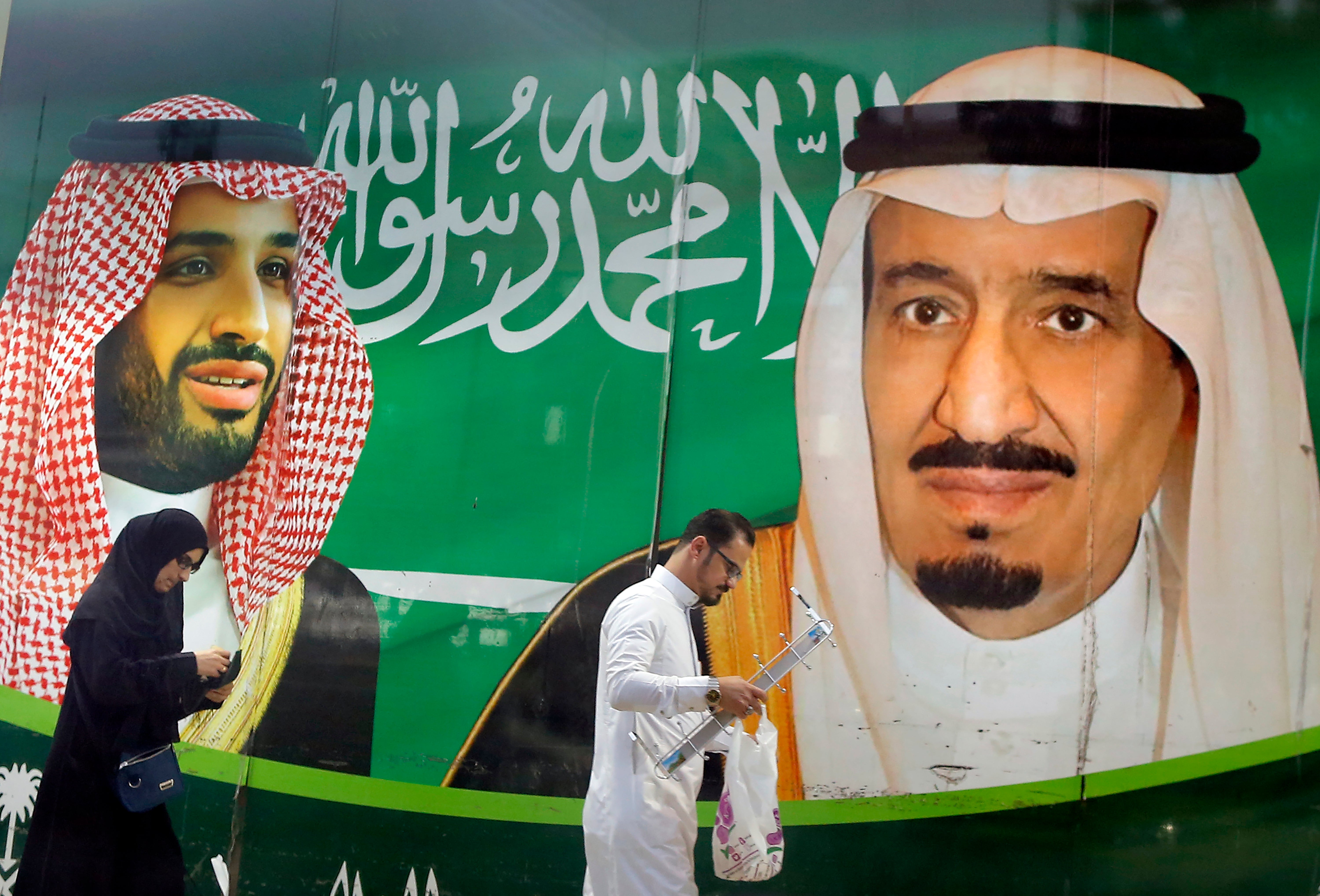 Imágenes del rey Salman (der)y el príncipe heredero Mohammed bin Salman (izq) afuera de un supermercado en Jeddah