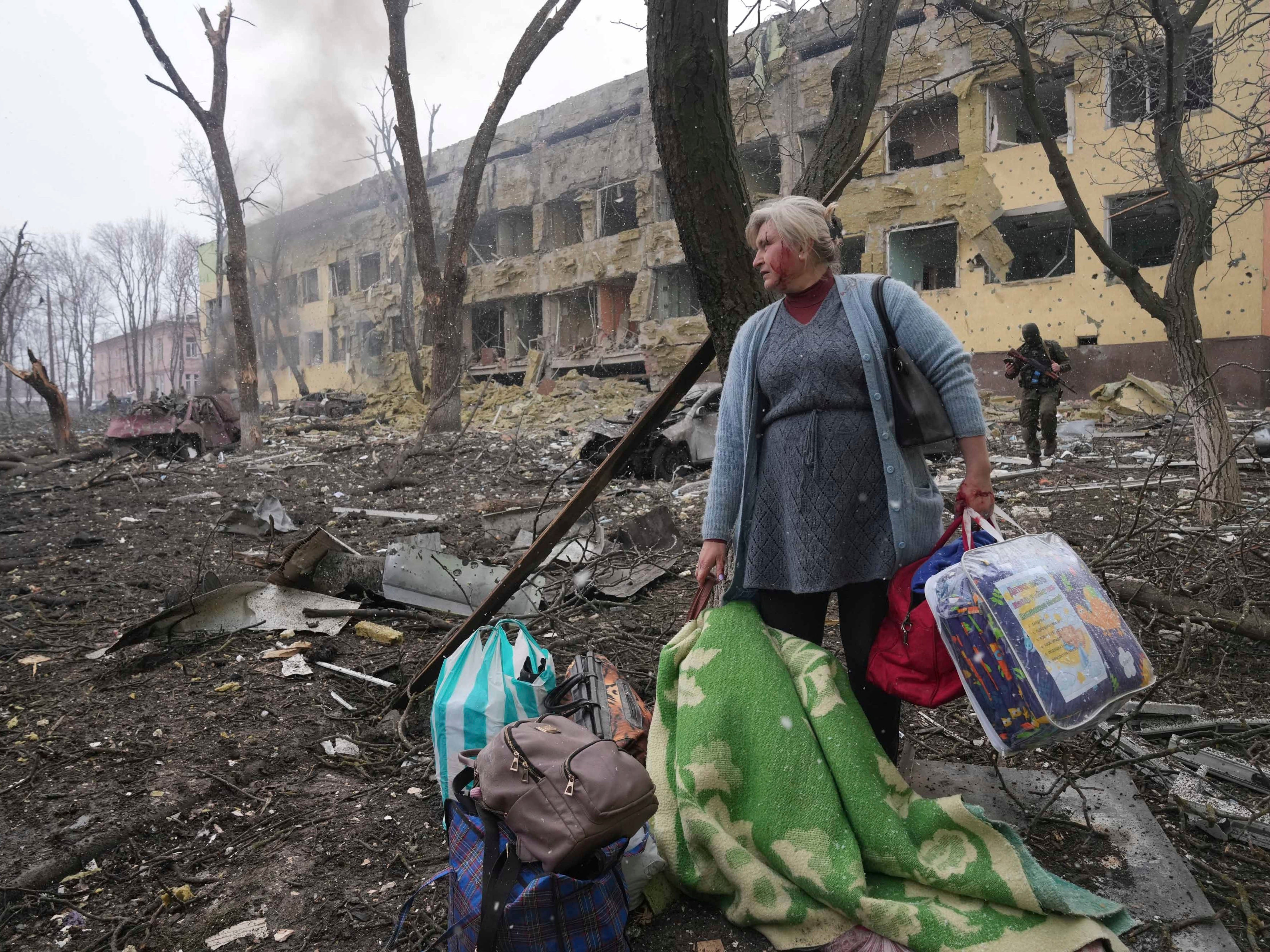 Una mujer camina fuera de un hospital de maternidad dañado por los bombardeos en Mariúpol