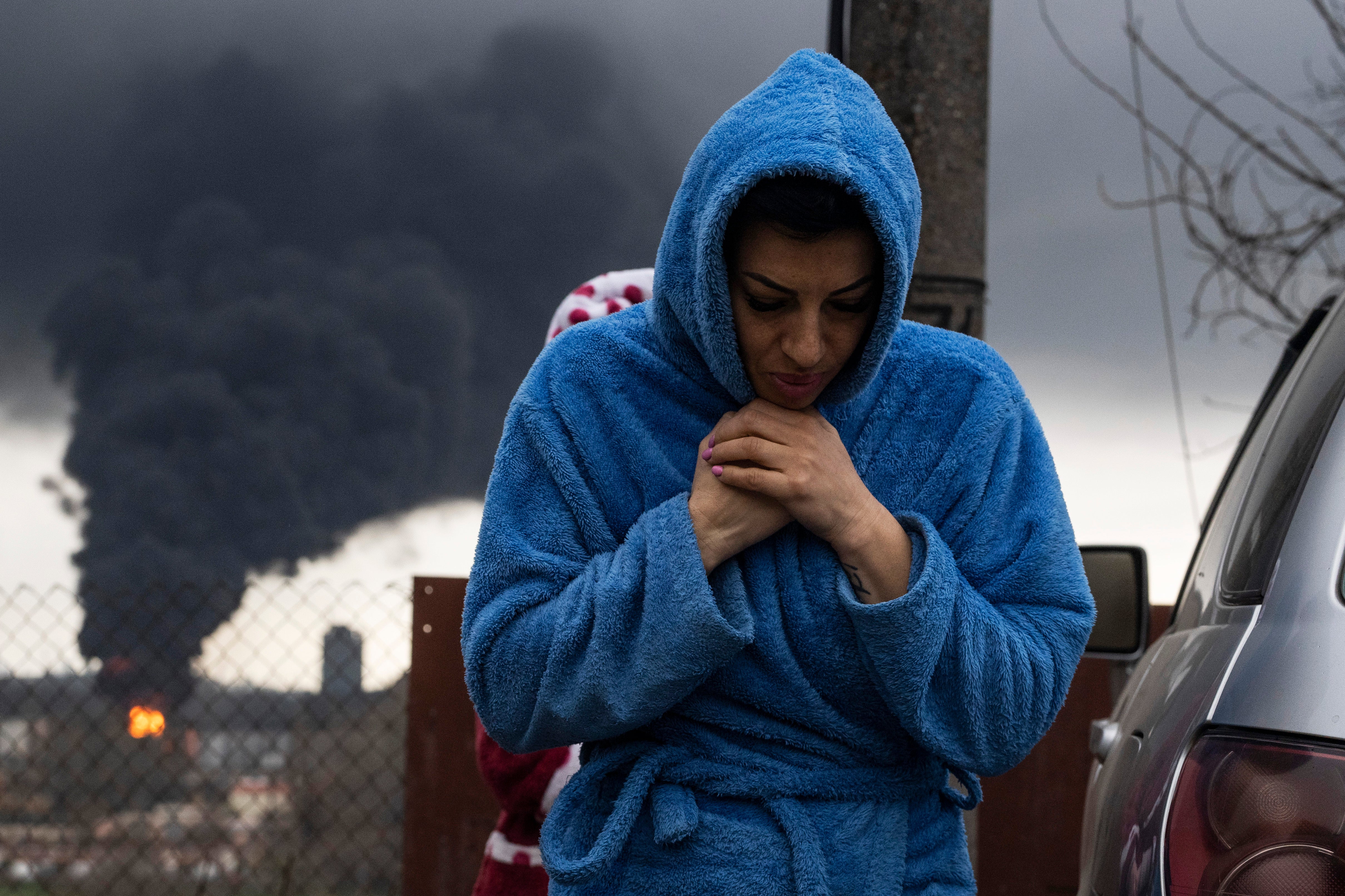 Una mujer en Odesa mientras emerge humo negro sobre el puerto del mar Negro después del ataque