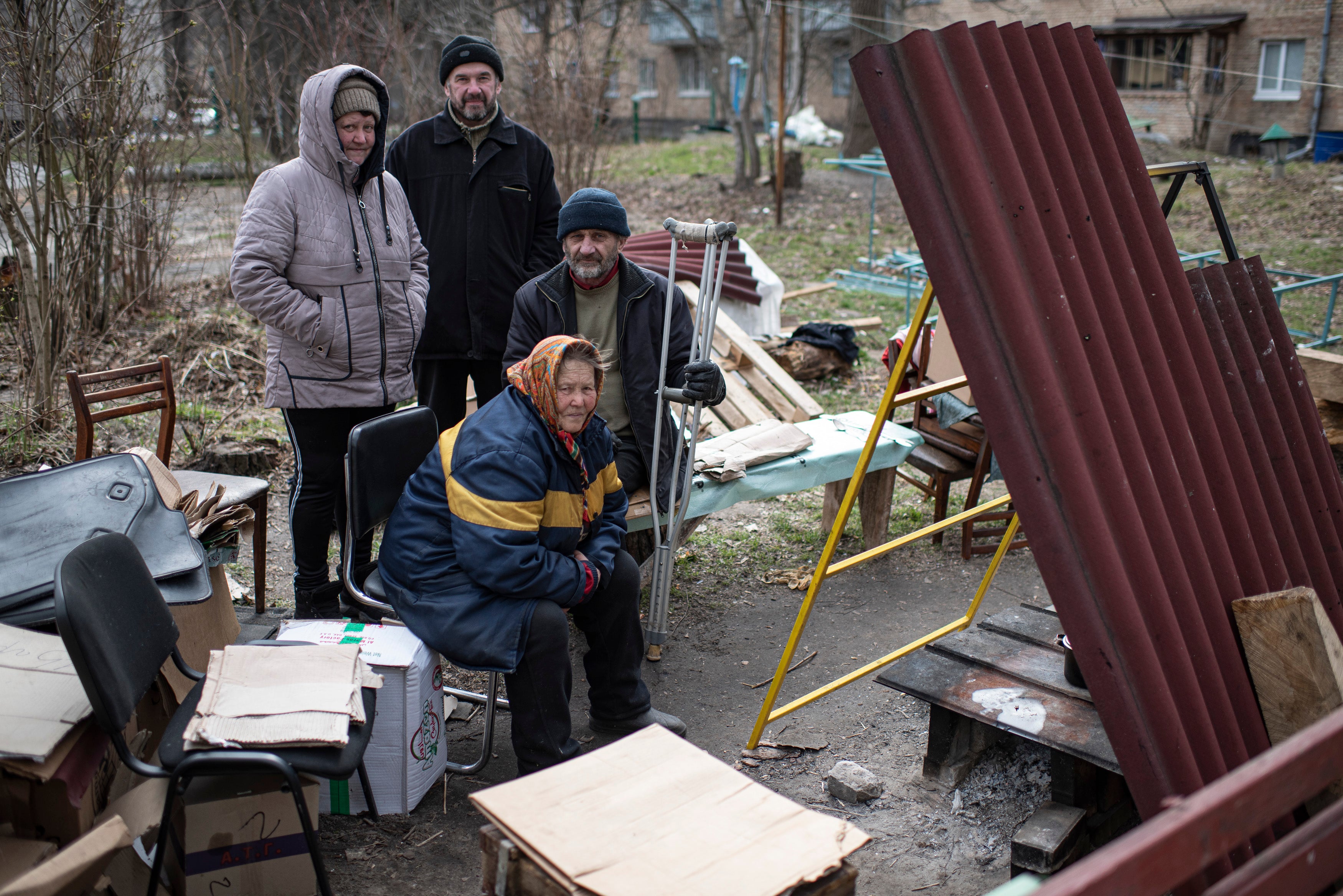 Un grupo de personas se sienta junto a una estufa improvisada al lado de su edificio de apartamentos en Bucha, Ucrania. El gobierno ucraniano ha acusado a las fuerzas rusas de cometer una “masacre deliberada” durante la ocupación y eventual retirada de Bucha
