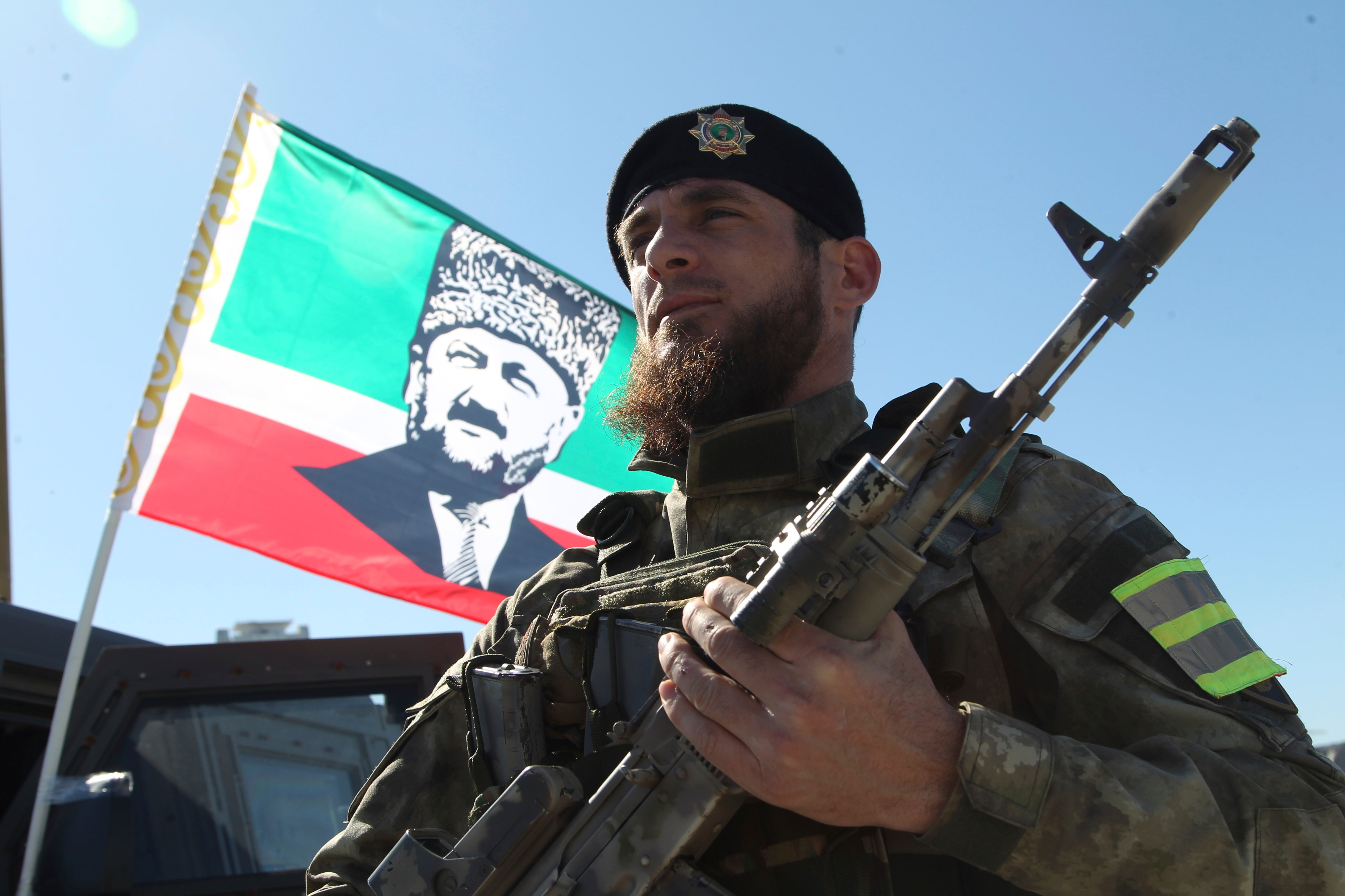 Un militar delante de una bandera de Akhmad Kadyrov y escuchando a Ramzan Kadyrov hablar a las tropas en Grozny, 29 de marzo de 2022