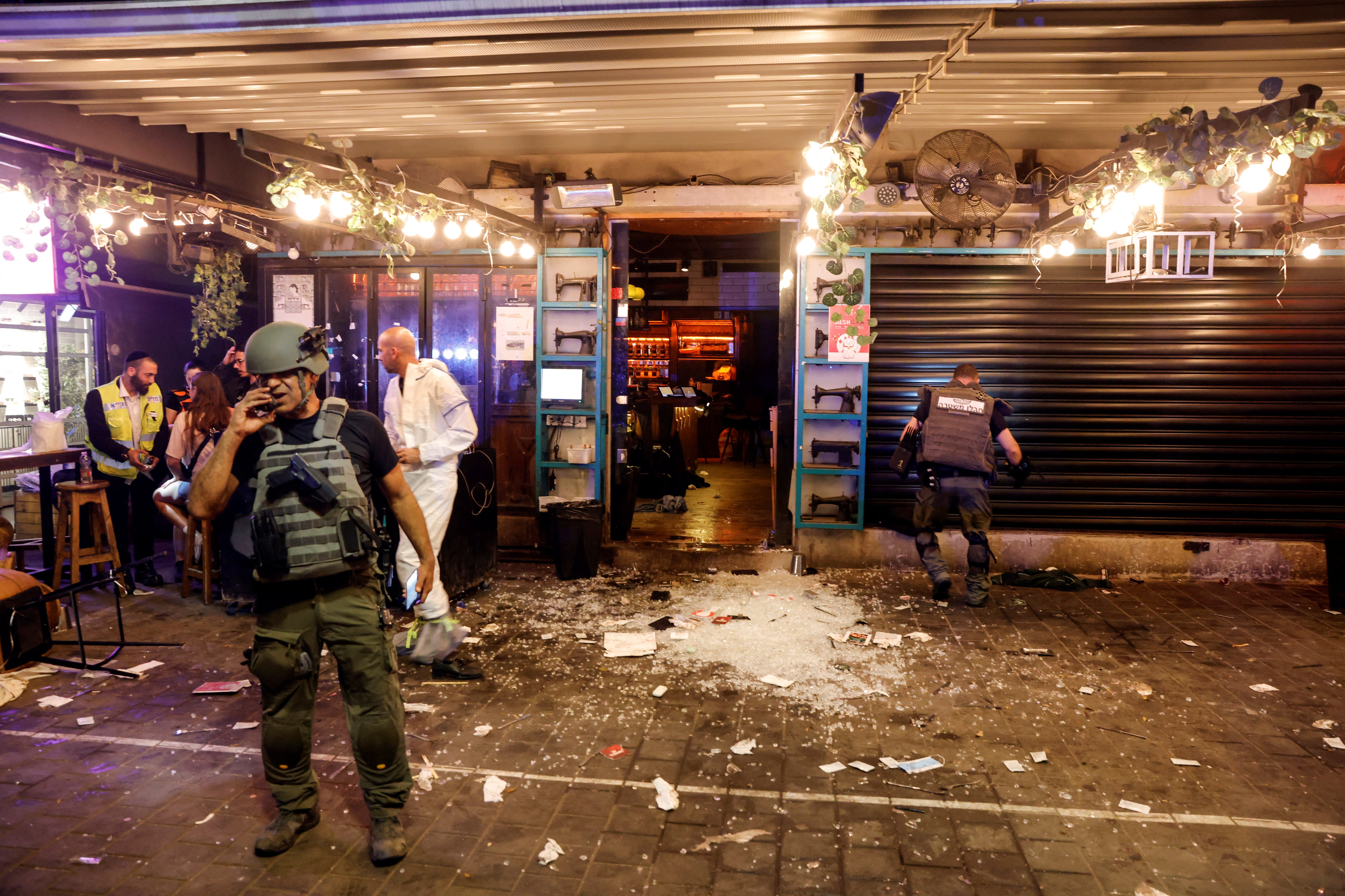 Personal de rescate y de seguridad de Israel trabaja junto a la entrada de un restaurante