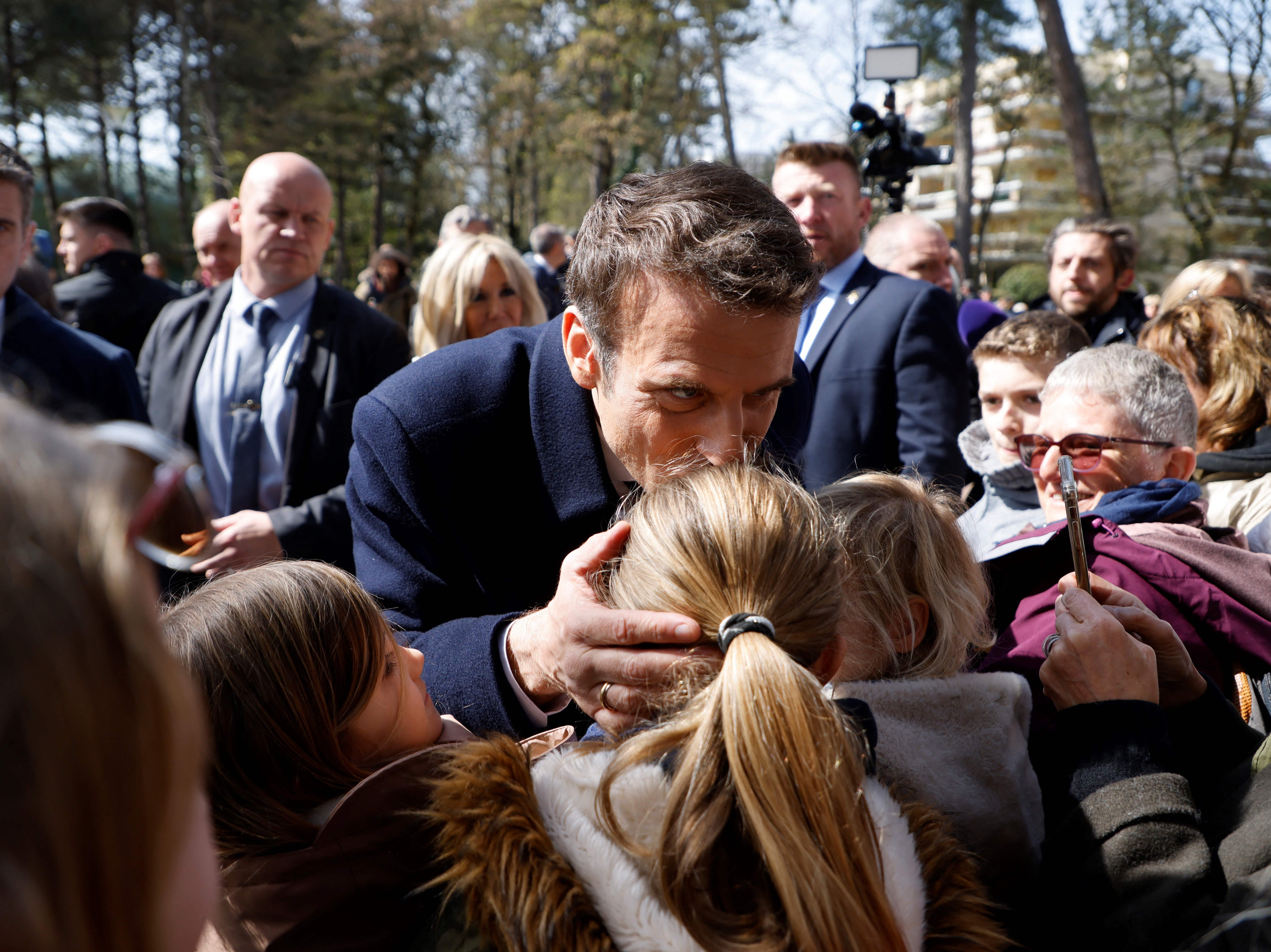 Emmanuel Macron besa a una niña en la frente mientras habla con reporteros tras emitir su voto en Le Touquet