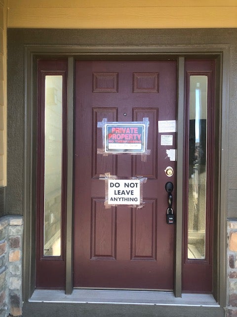La puerta de la casa de Watts en Frederick, Colorado, está cerrada con candado y hay carteles que advierten a los curiosos de que se mantengan alejados de la propiedad