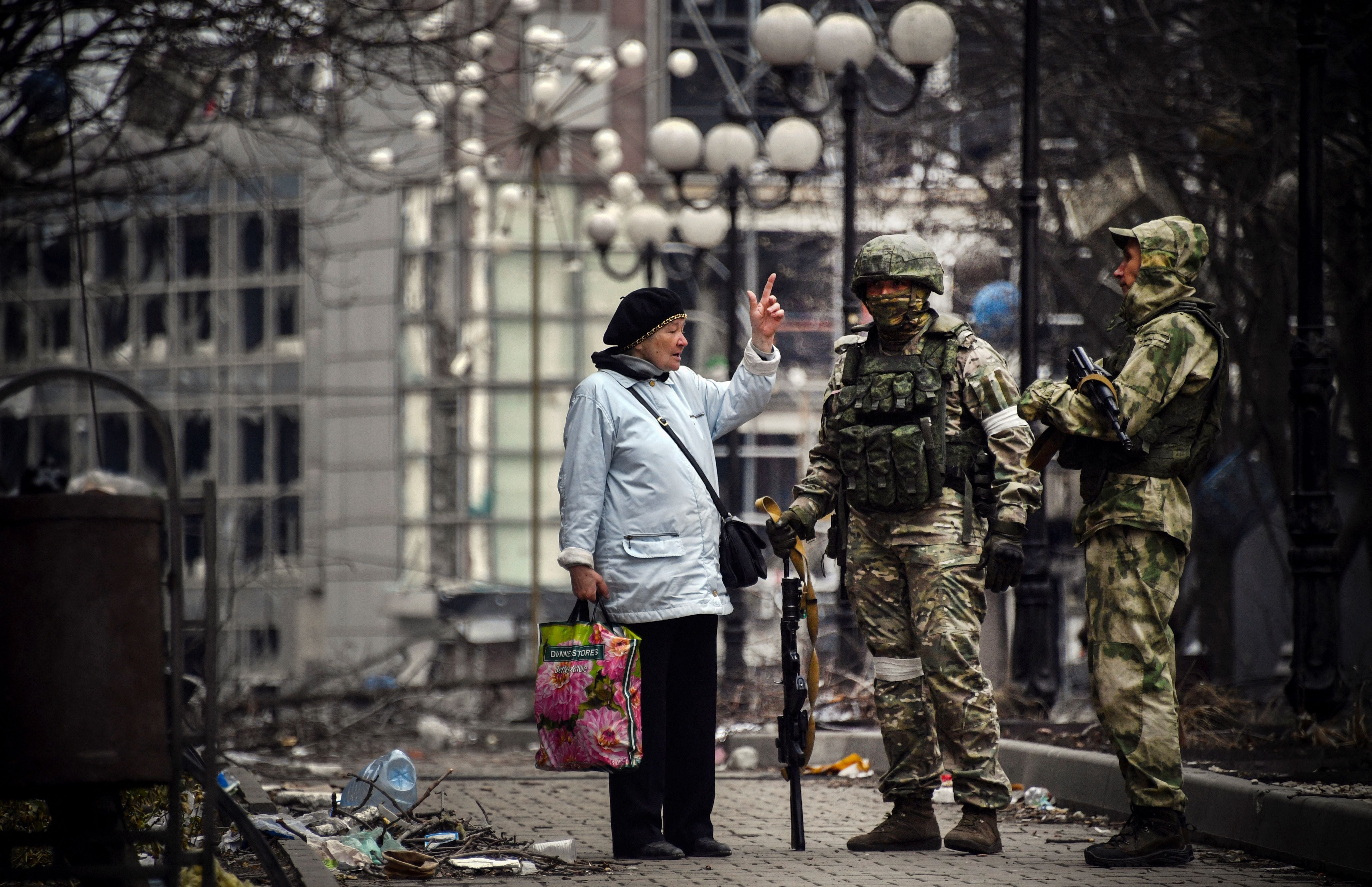 Una mujer habla con soldados rusos en Mariúpol el 12 de abril