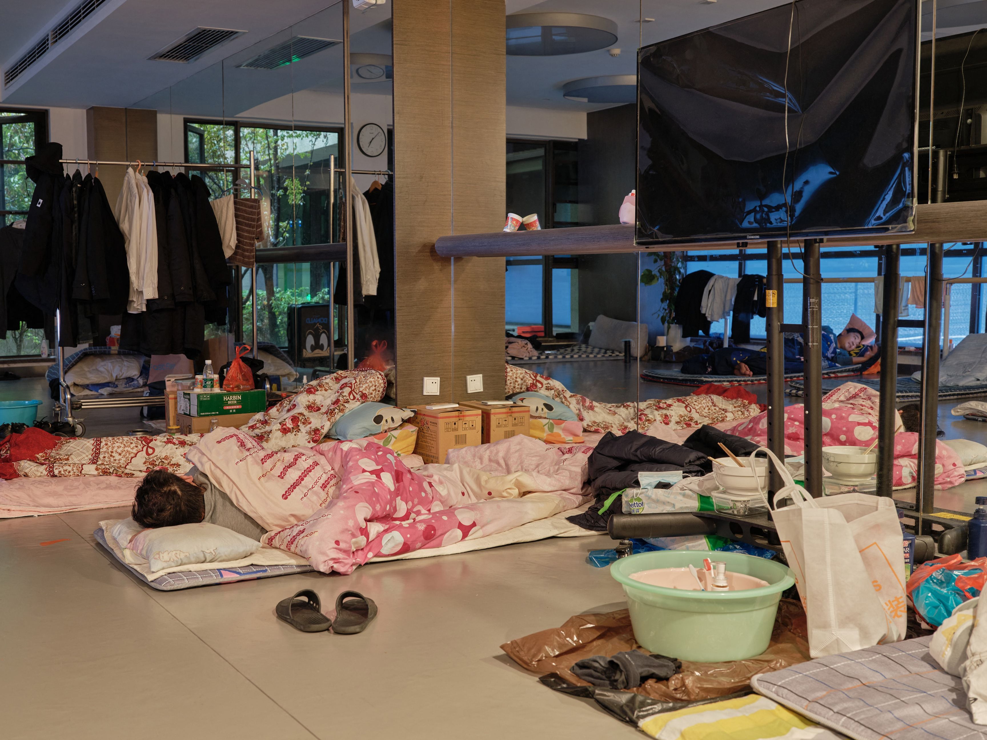 Un trabajador comunitario toma una siesta en una cama temporal en un gimnasio durante un confinamiento por covid-19 en el distrito Pudong de Shanghái