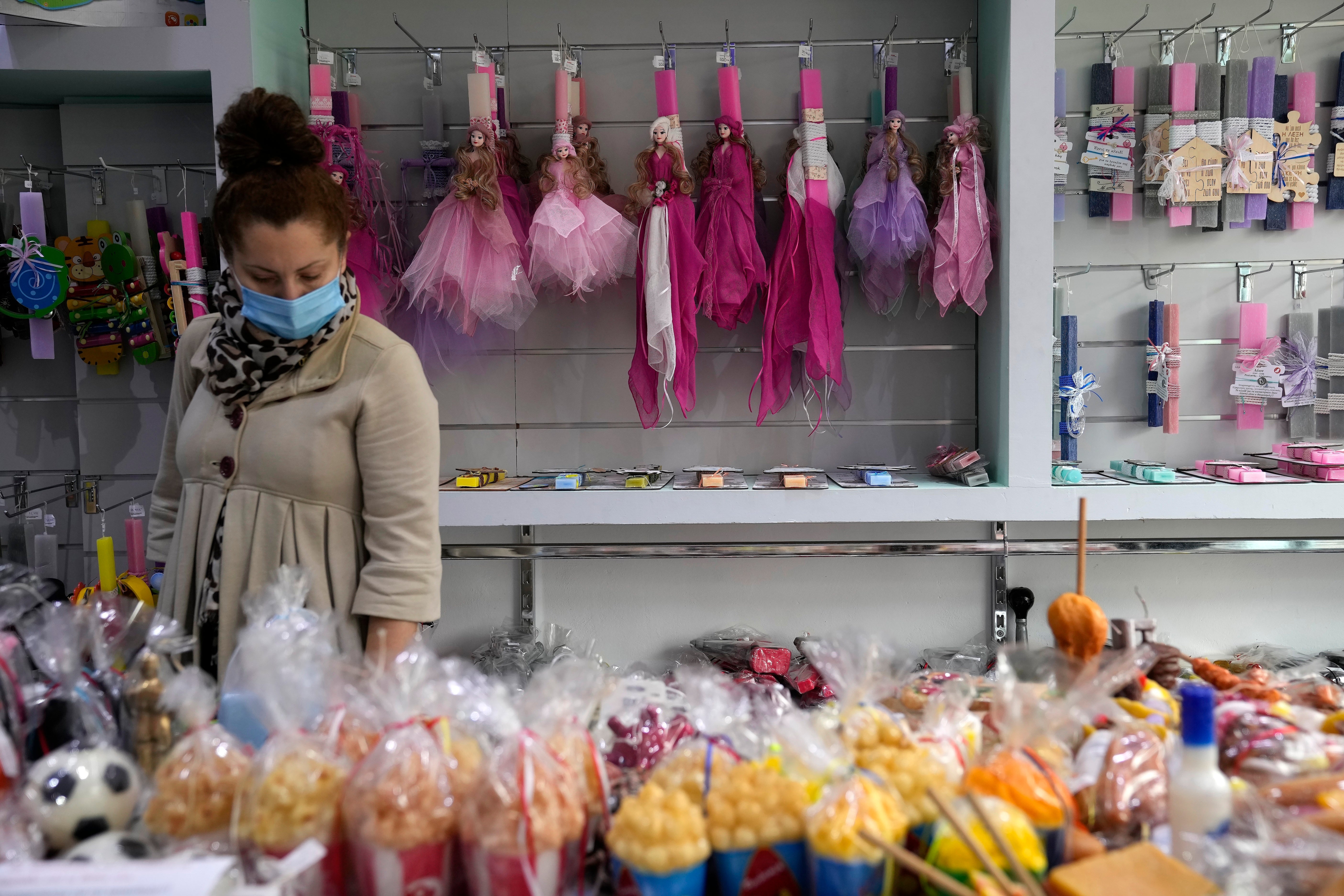 Una mujer compra velas en una tienda de Atenas (Grecia)