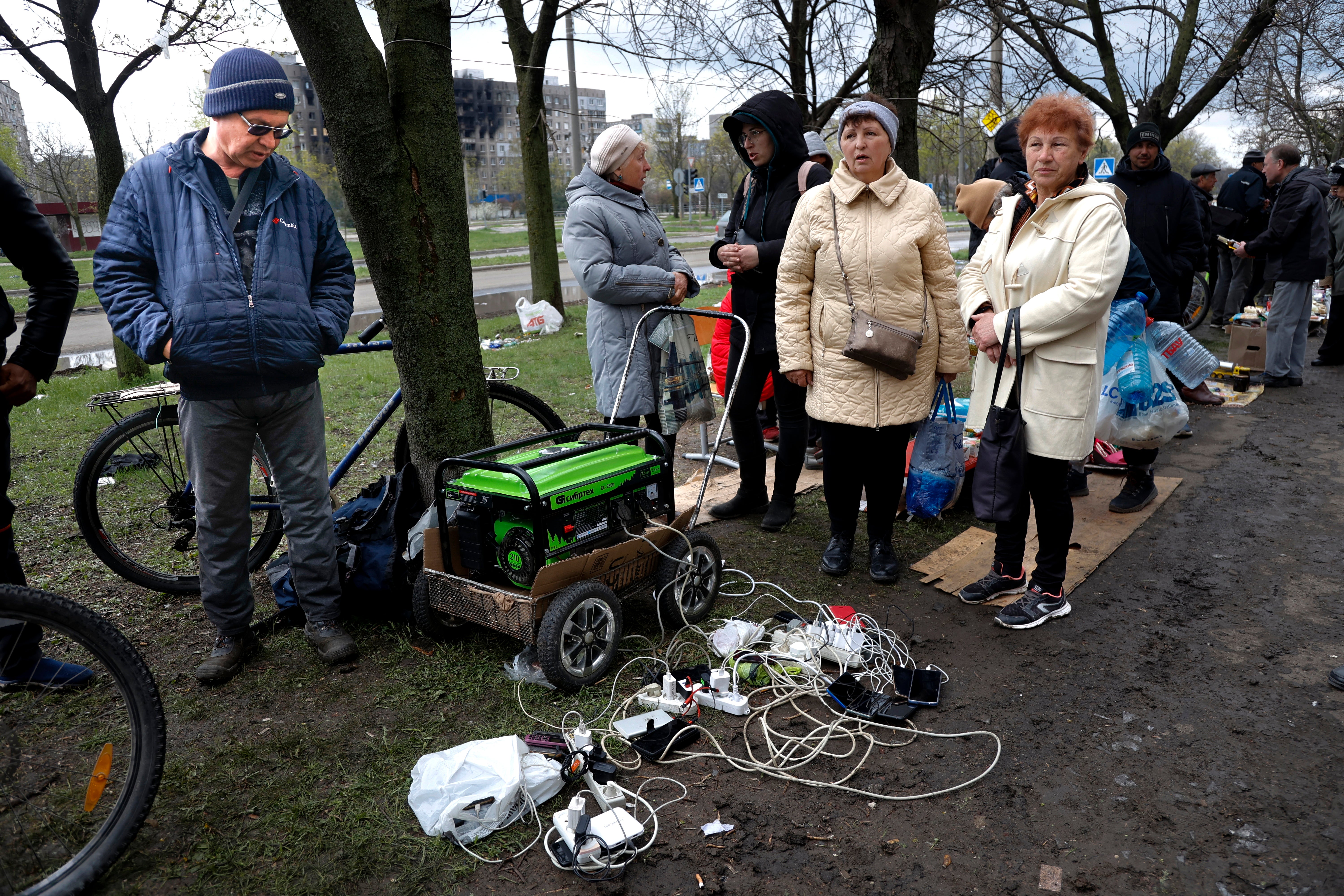 Residentes locales se reúnen cerca de un generador para cargar sus dispositivos móviles en una zona controlada por las fuerzas separatistas respaldadas por Rusia en Mariúpol