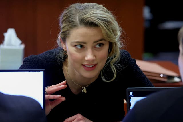La actriz Amber Heard habla con su equipo legal durante el juicio por difamación de su exmarido Johnny Depp en su contra, en el juzgado de circuito del condado de Fairfax en Fairfax, Virginia, EE. UU., el 28 de abril de 2022.
