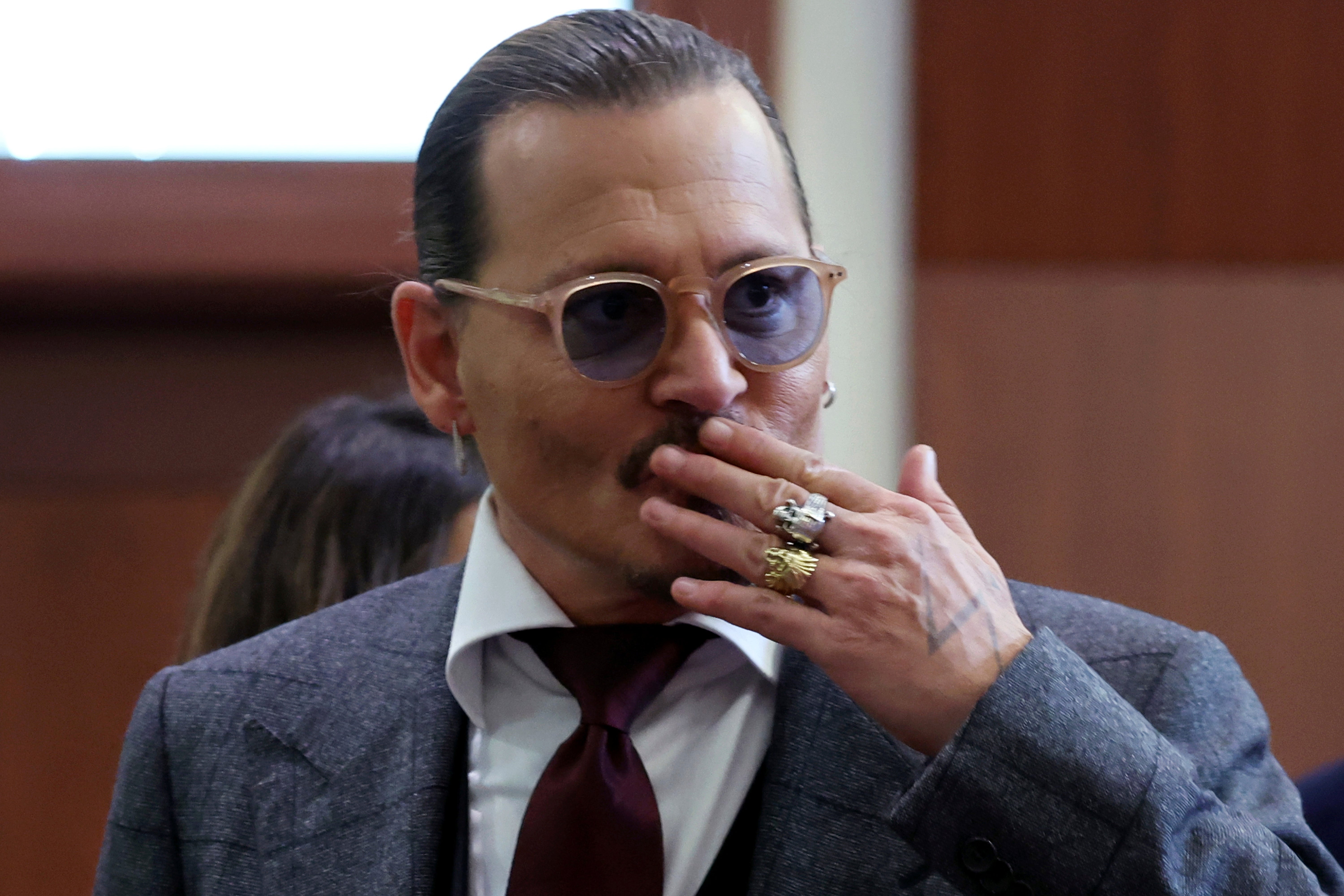 El actor Johnny Depp reacciona ante los fans en la sala del tribunal el jueves