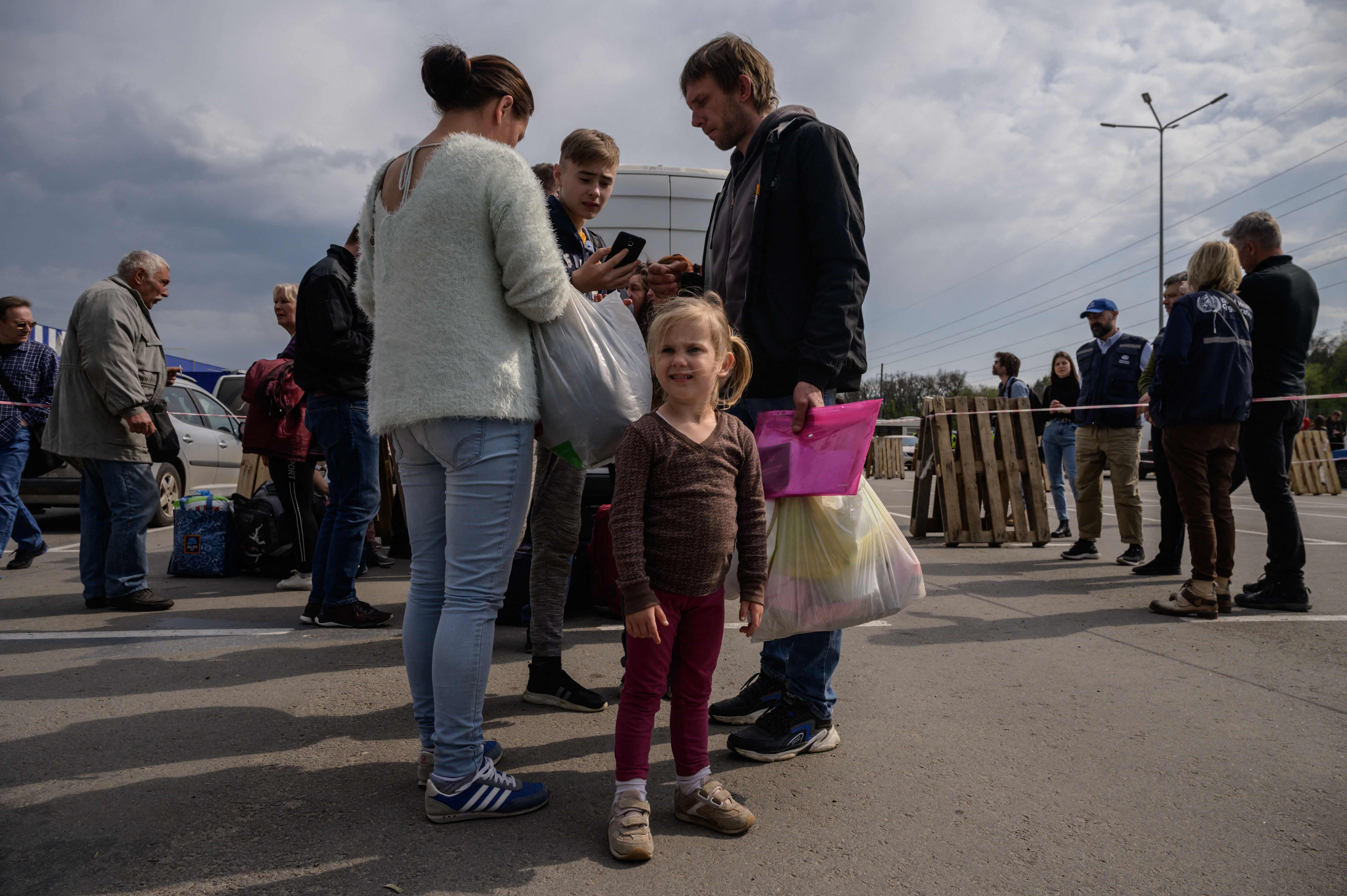 Una familia llega desde Melitopol, ocupada por Rusia, a una zona de registro y tramitación de desplazados internos en Zaporizhzhia, antes de un esperado convoy humanitario