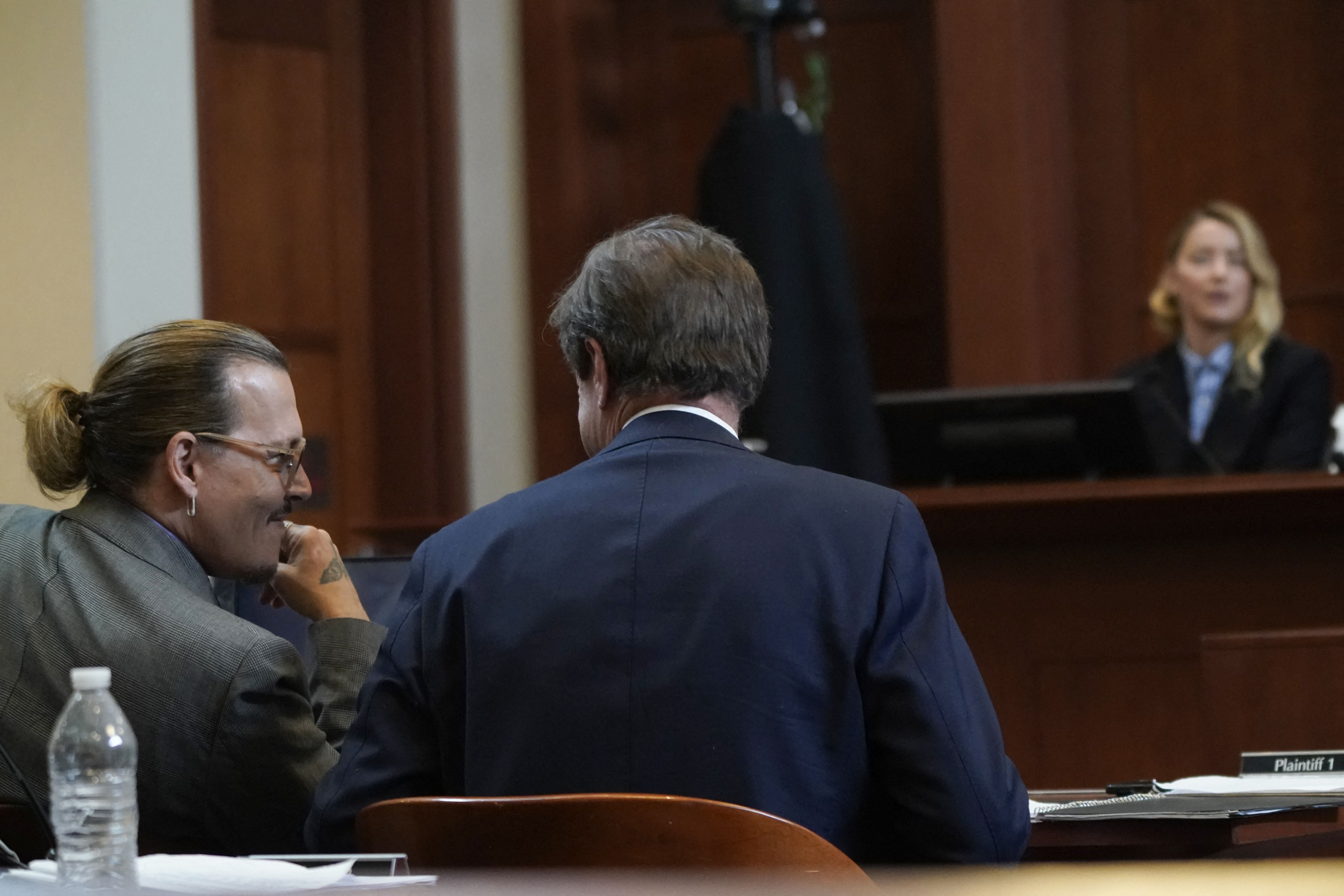 Johnny Depp reacciona junto a su abogado Ben Chew mientras Amber Heard declara en el juzgado del condado de Fairfax el 4 de mayo de 2022