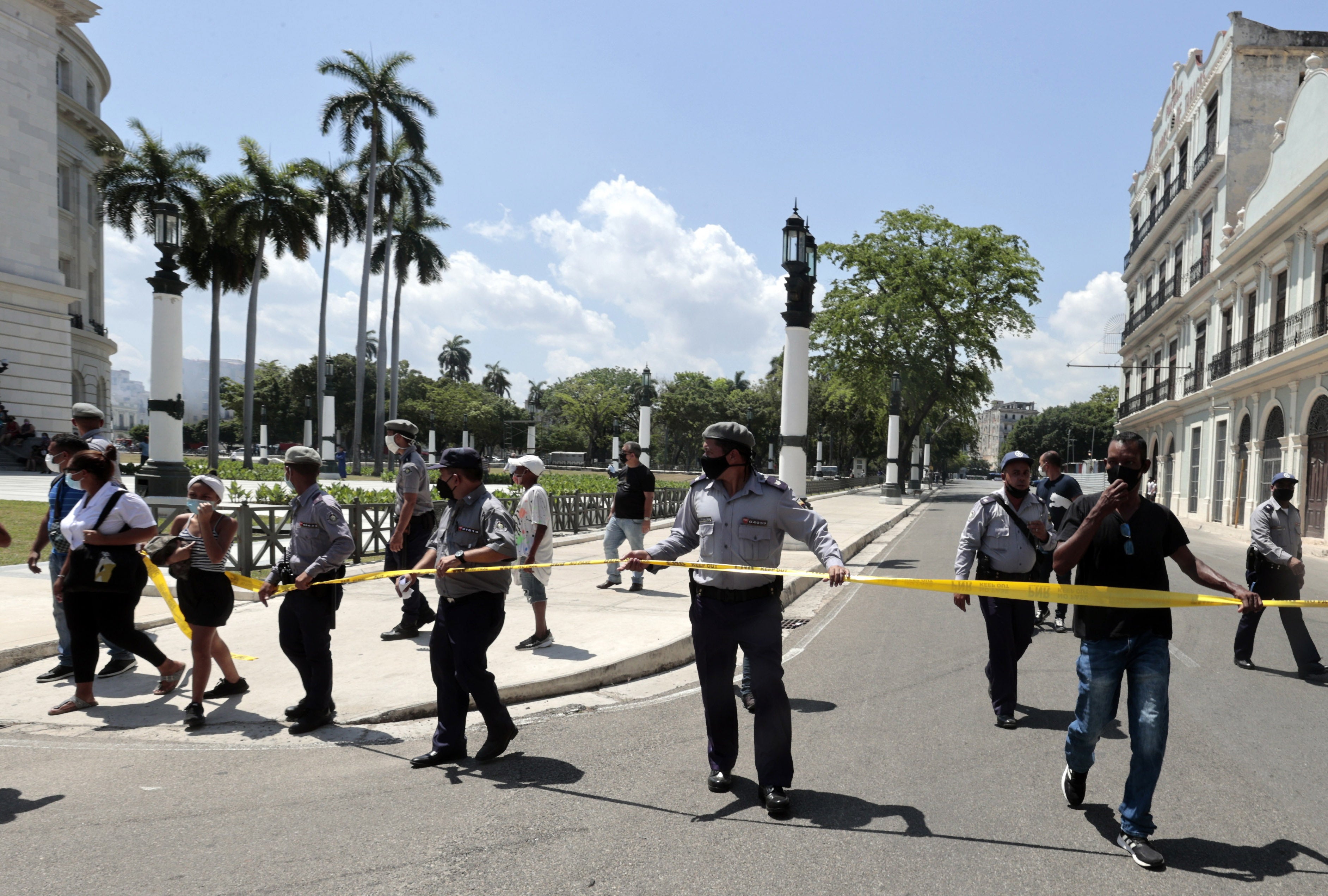 Miembros de la policía alejan a la gente de la zona donde se registró una explosión en el Hotel Saratoga, en La Habana, Cuba, 6 de mayo de 2022