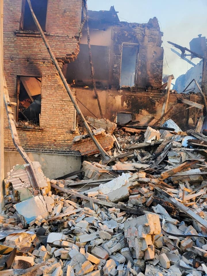 Escombros junto a un edificio parcialmente derrumbado tras el impacto en un edificio escolar