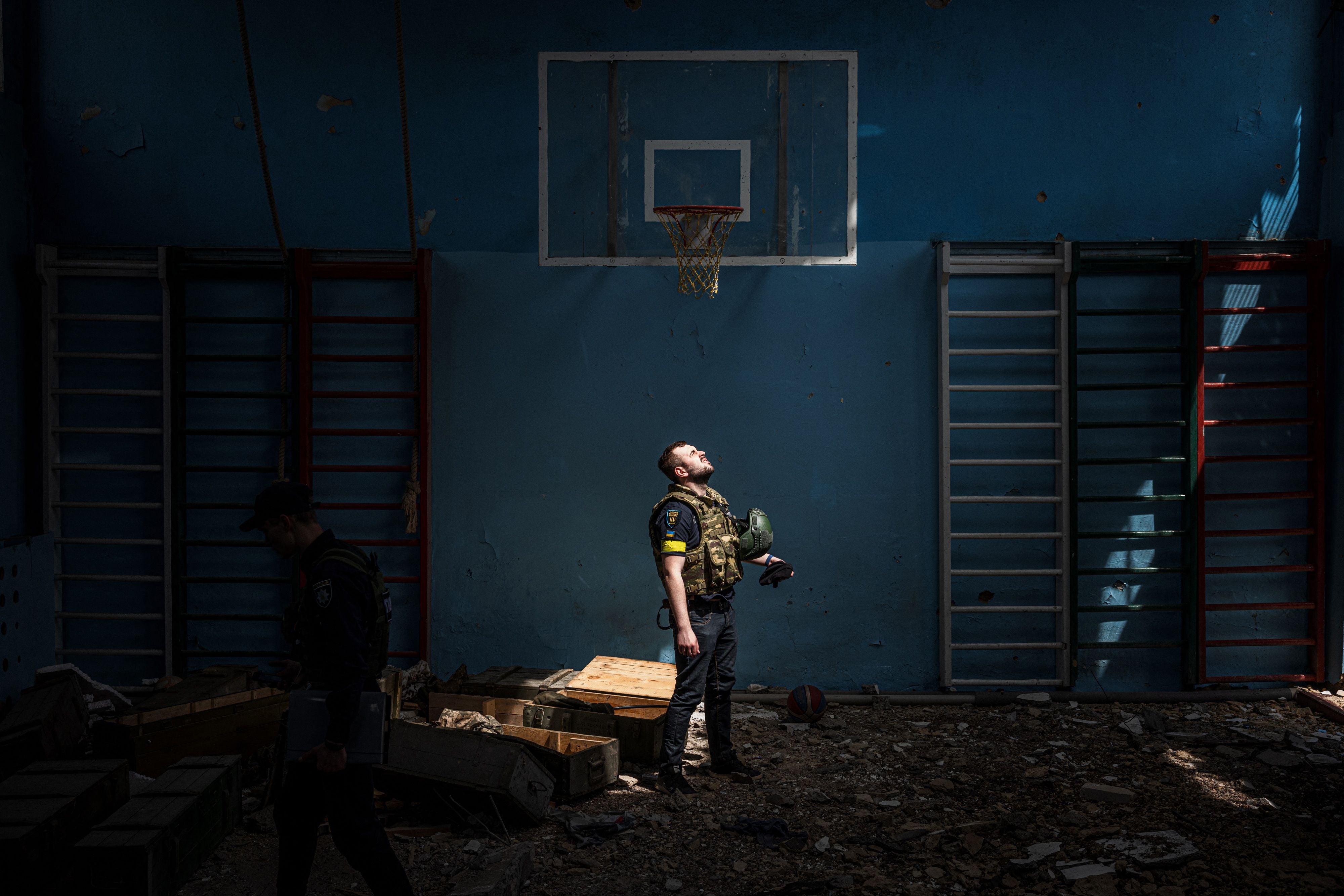 Un policía ucraniano parado afuera del gimnasio de una escuela afectada en Vilkhivka