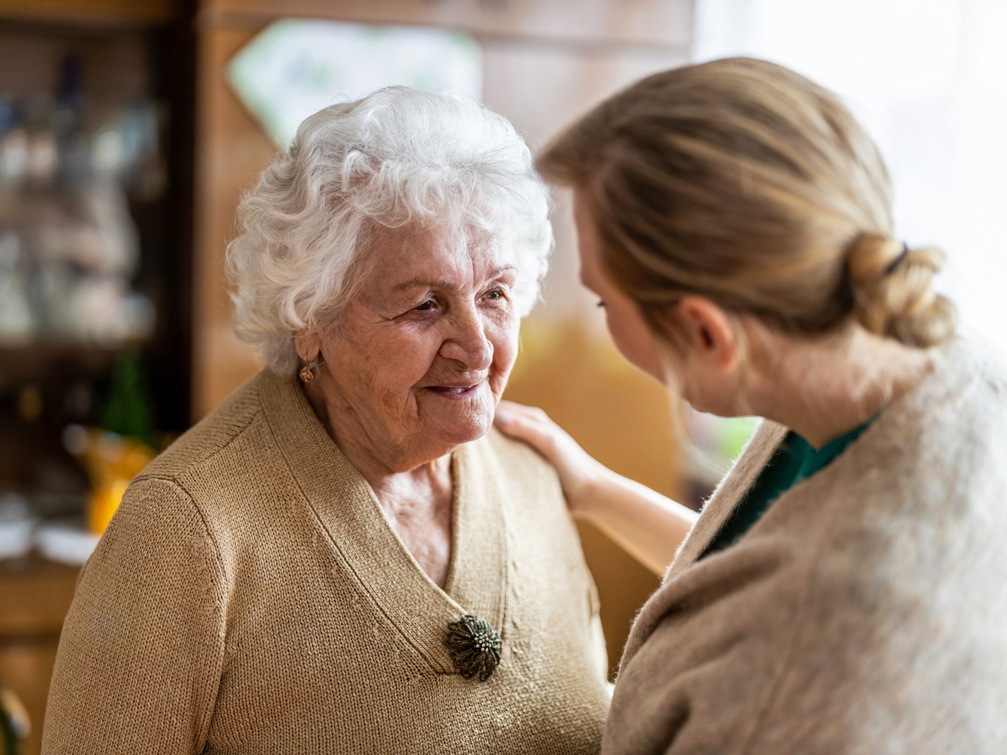 A health visitor talking to a senior citizen during a home visit