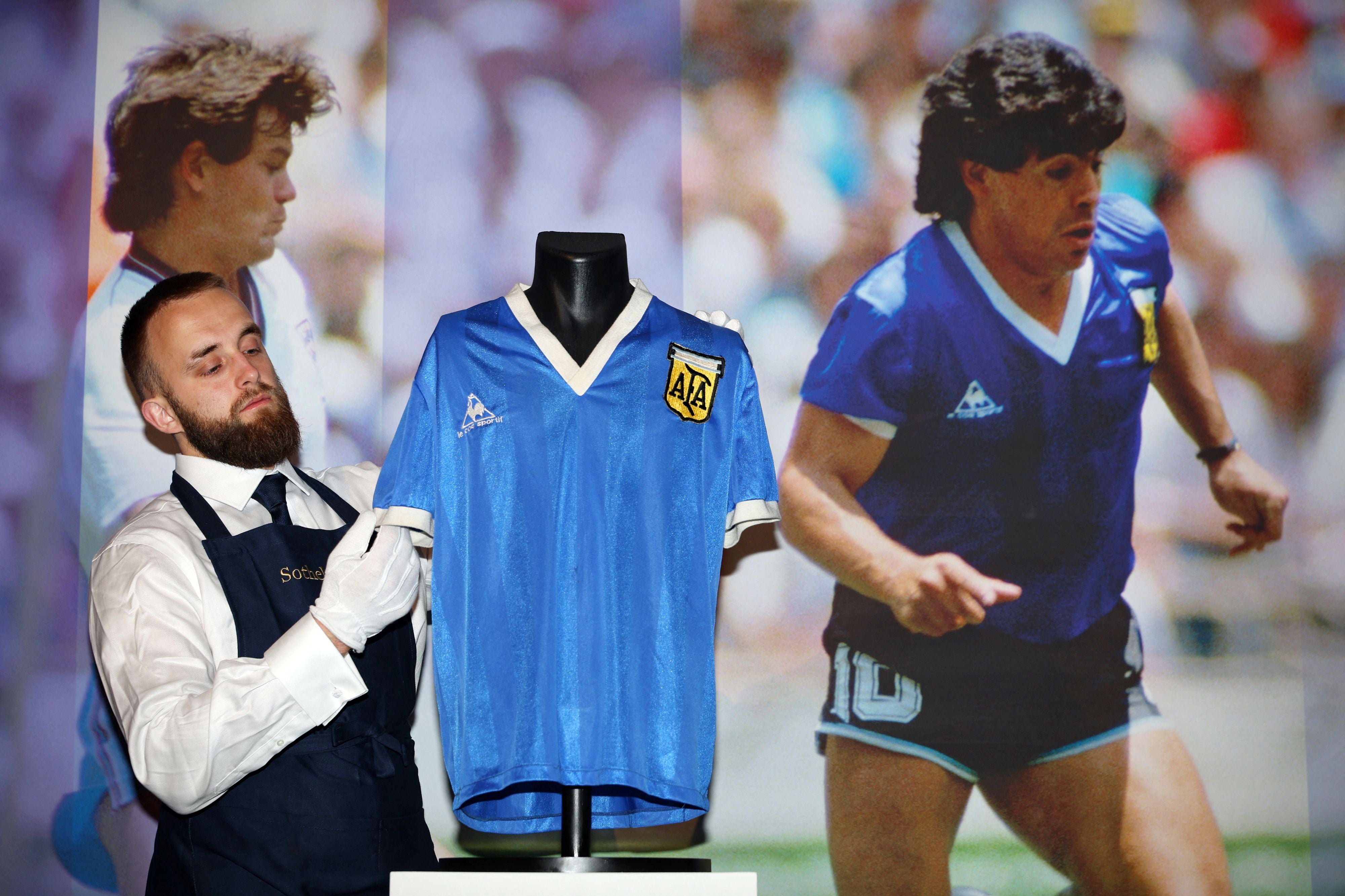 Un técnico de Sotheby's ajusta la camiseta que llevaba el argentino Diego Armando Maradona durante el partido de cuartos de final del Mundial de 1986 contra Inglaterra