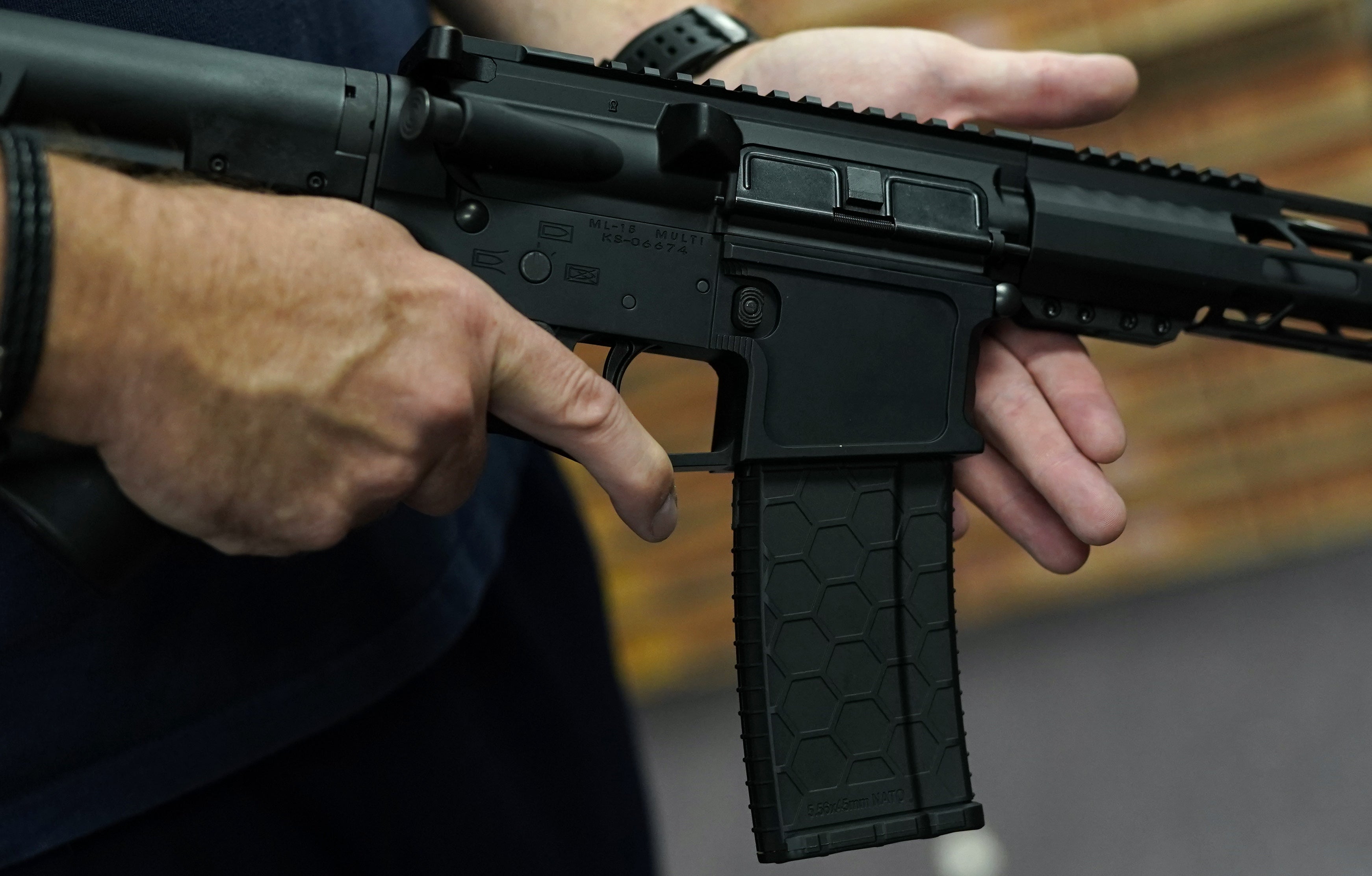 Un cliente muestra un rifle AR-15 en una tienda en Nueva York