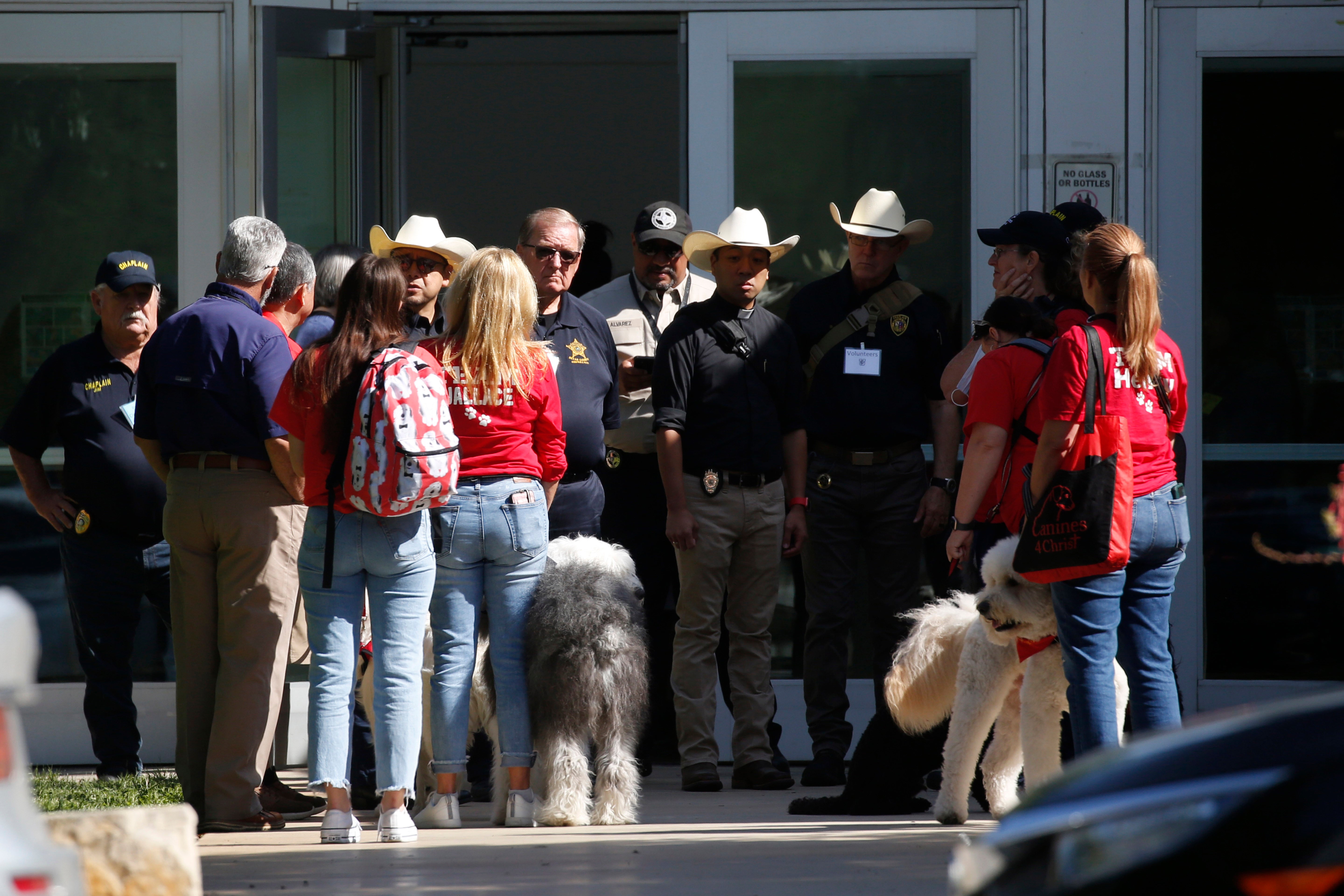 La policía y los miembros de la unidad de perros de terapia del Centro Médico del Ejército Brooke se reúnen fuera del Centro Cívico en Uvalde, Texas, el miércoles 25 de mayo de 202; el atacante de 18 años que masacró a 19 niños y dos profesores en una escuela primaria de Texas se atrincheró dentro de un solo salón de clases y “comenzó a disparar a cualquiera que se interpusiera en su camino”, dijeron las autoridades el miércoles al detallar el último asesinato masivo que sacude a Estados Unidos (AP Photo/Dario Lopez-Mills)