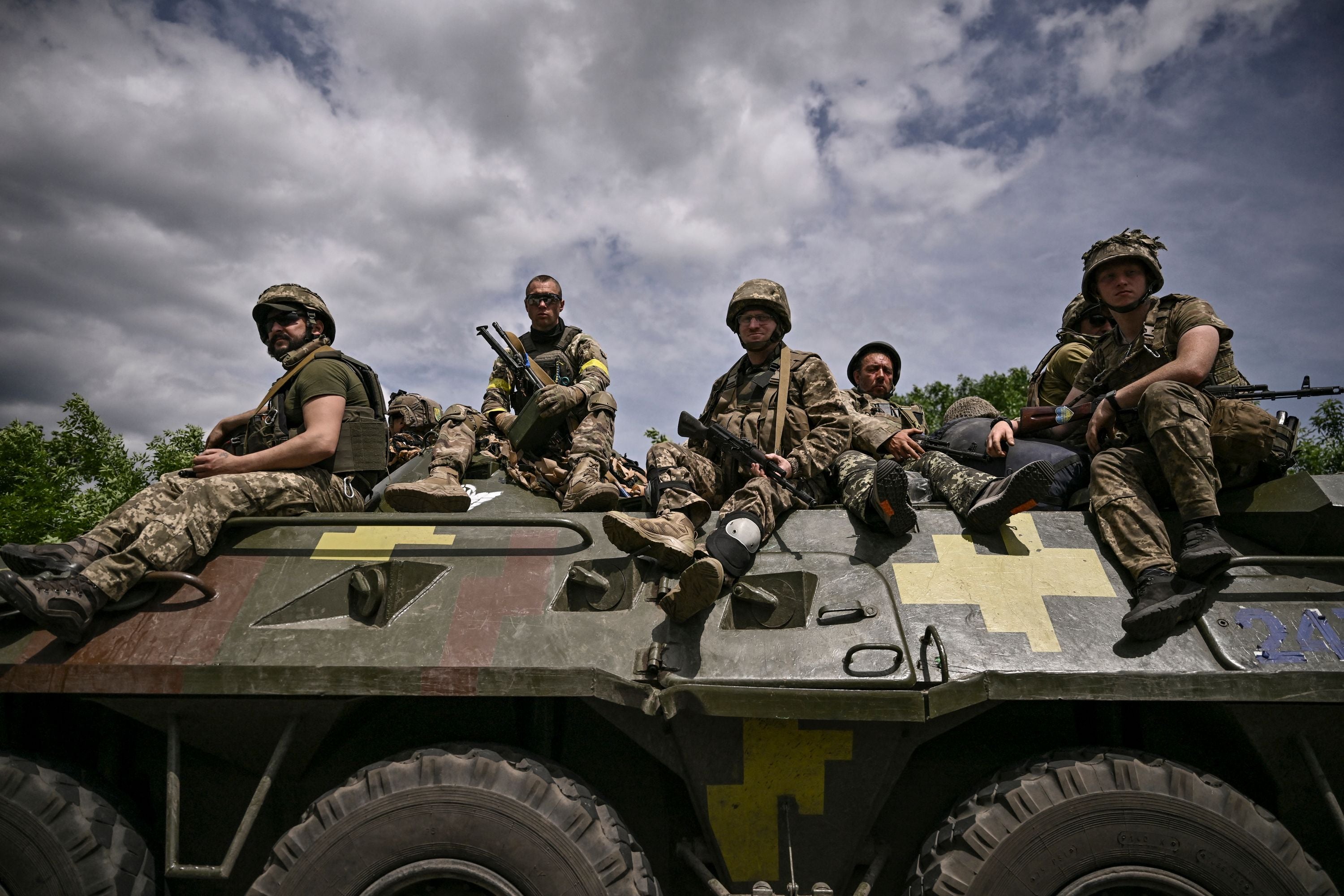 Tropas ucranianan sentadas sobre un vehículo blindado mientras regresan del frente cerca de la ciudad de Slovyansk, en el Donbas