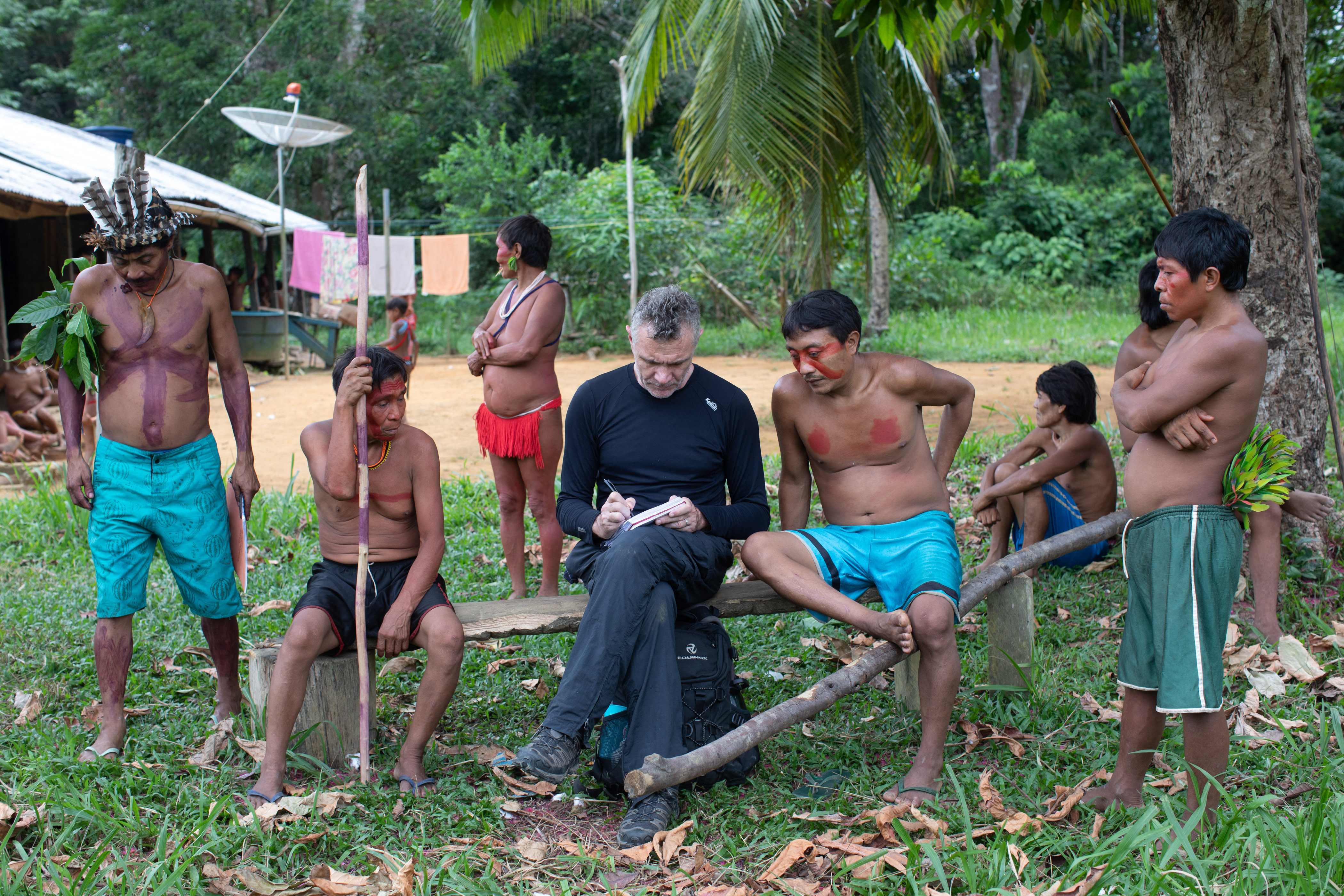 Dom Phillips toma notas al hablar con las personas indígenas de Aldeia Maloca