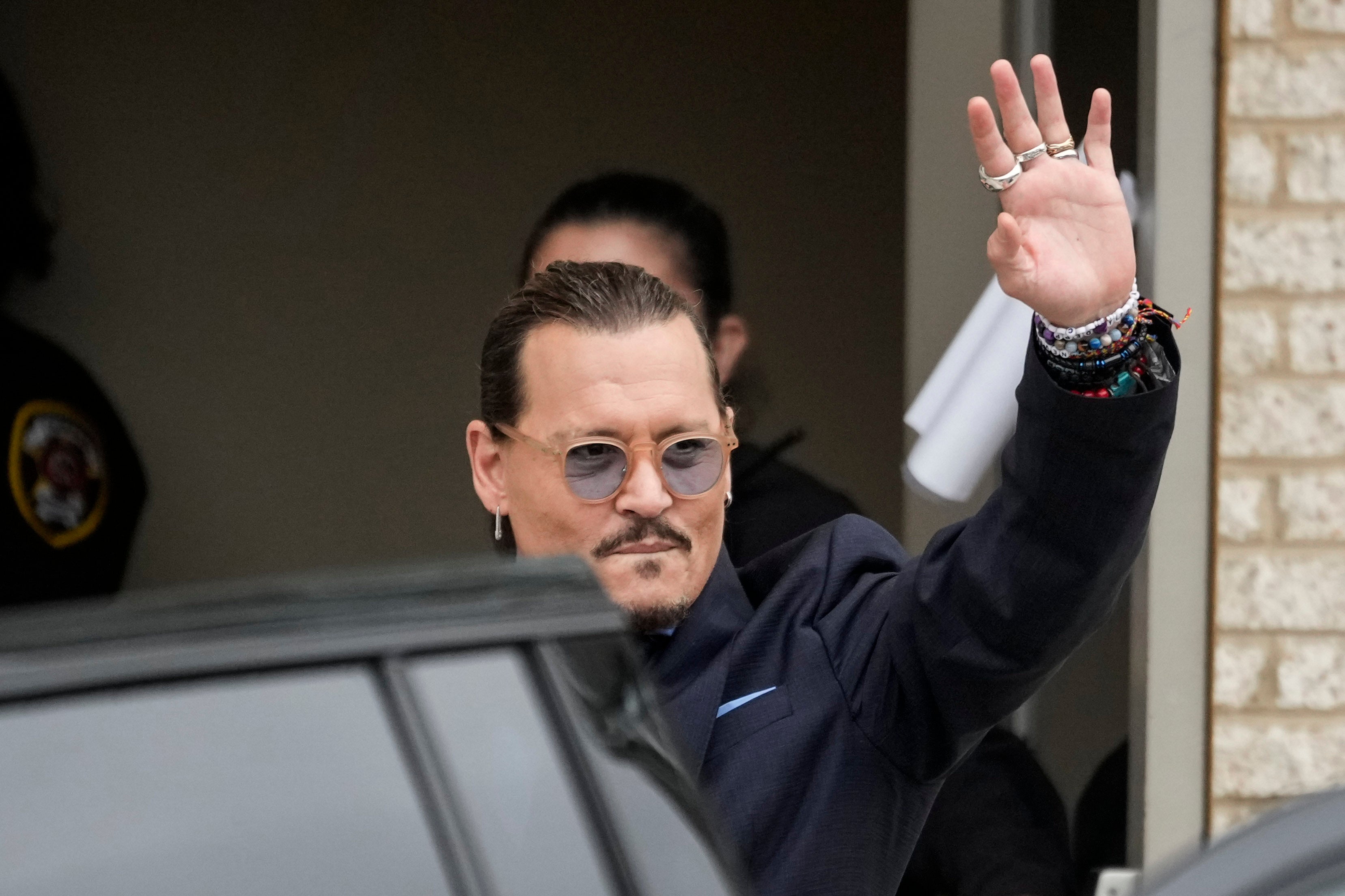Johnny Depp saluda a sus fans fuera del tribunal durante el juicio