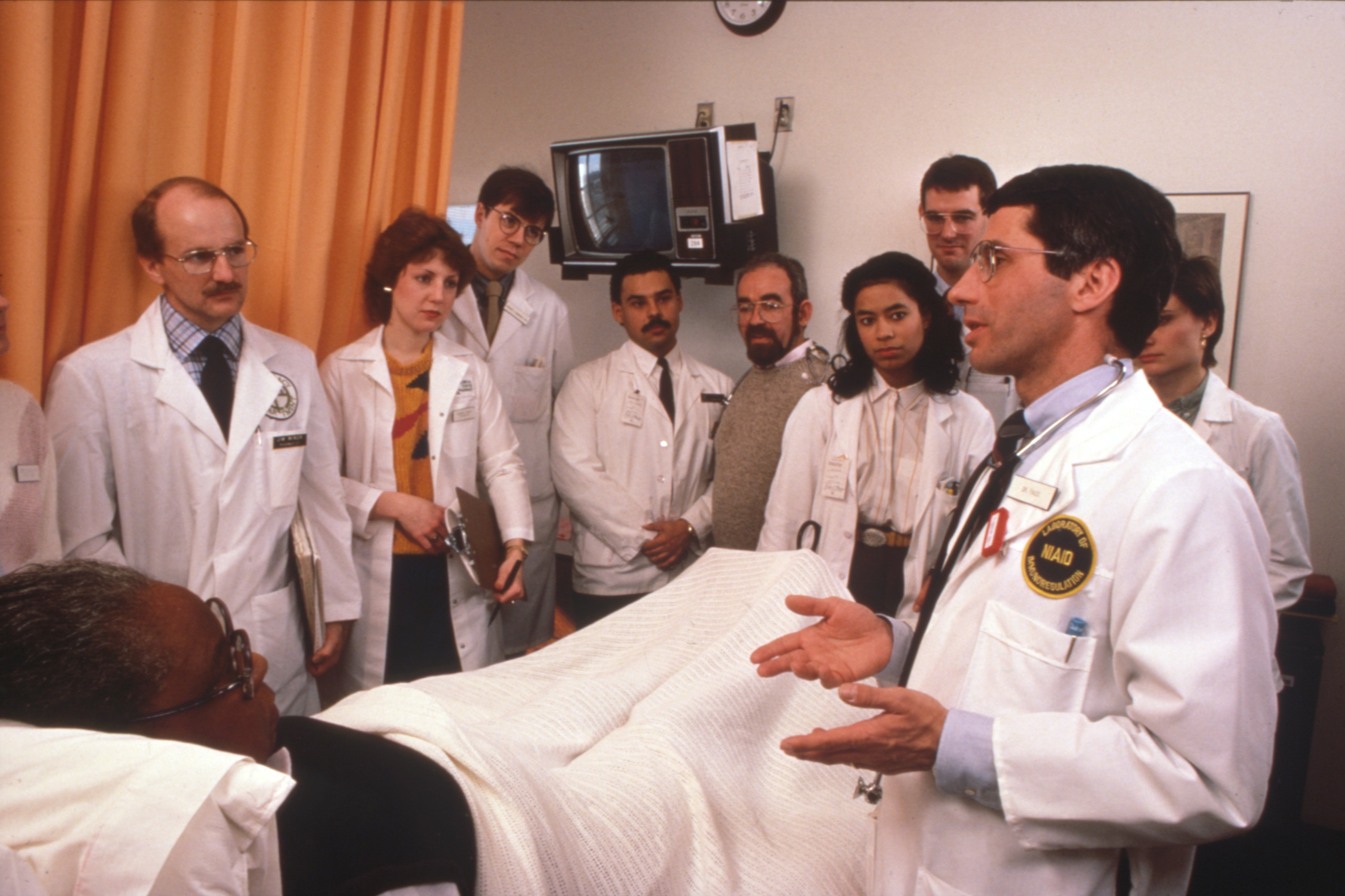 El Dr. Anthony Fauci y un equipo de tratamiento con uno de los primeros pacientes de SIDA durante rondas de revisión en el NIH, circa 1986