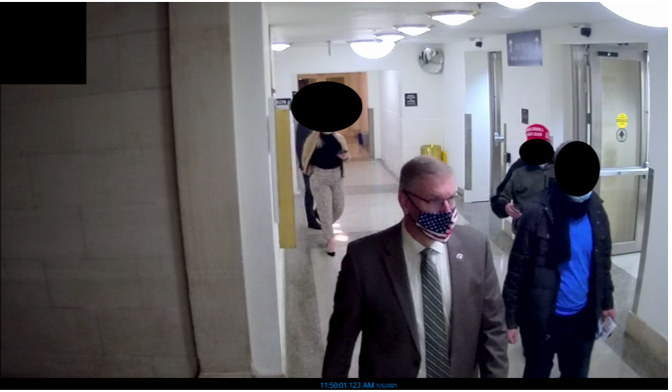 Esta imagen tomada del vídeo de vigilancia del Capitolio muestra al diputado Barry Loudermilk dirigiendo una visita el día antes de los disturbios en el Capitolio