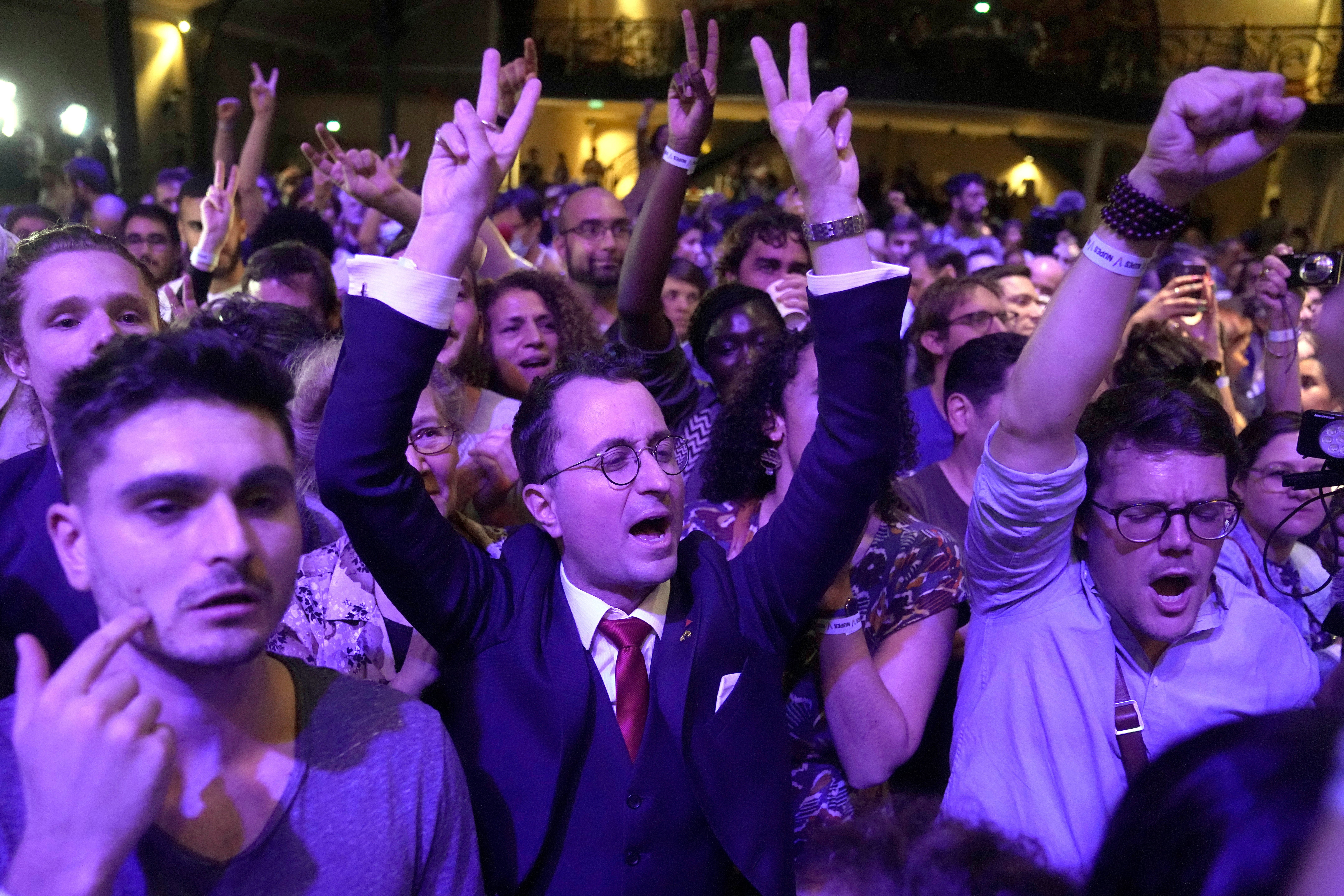 Los partidarios del líder de la izquierda dura Jean-Luc Melenchon reaccionan dentro de su cuartel general de la noche electoral