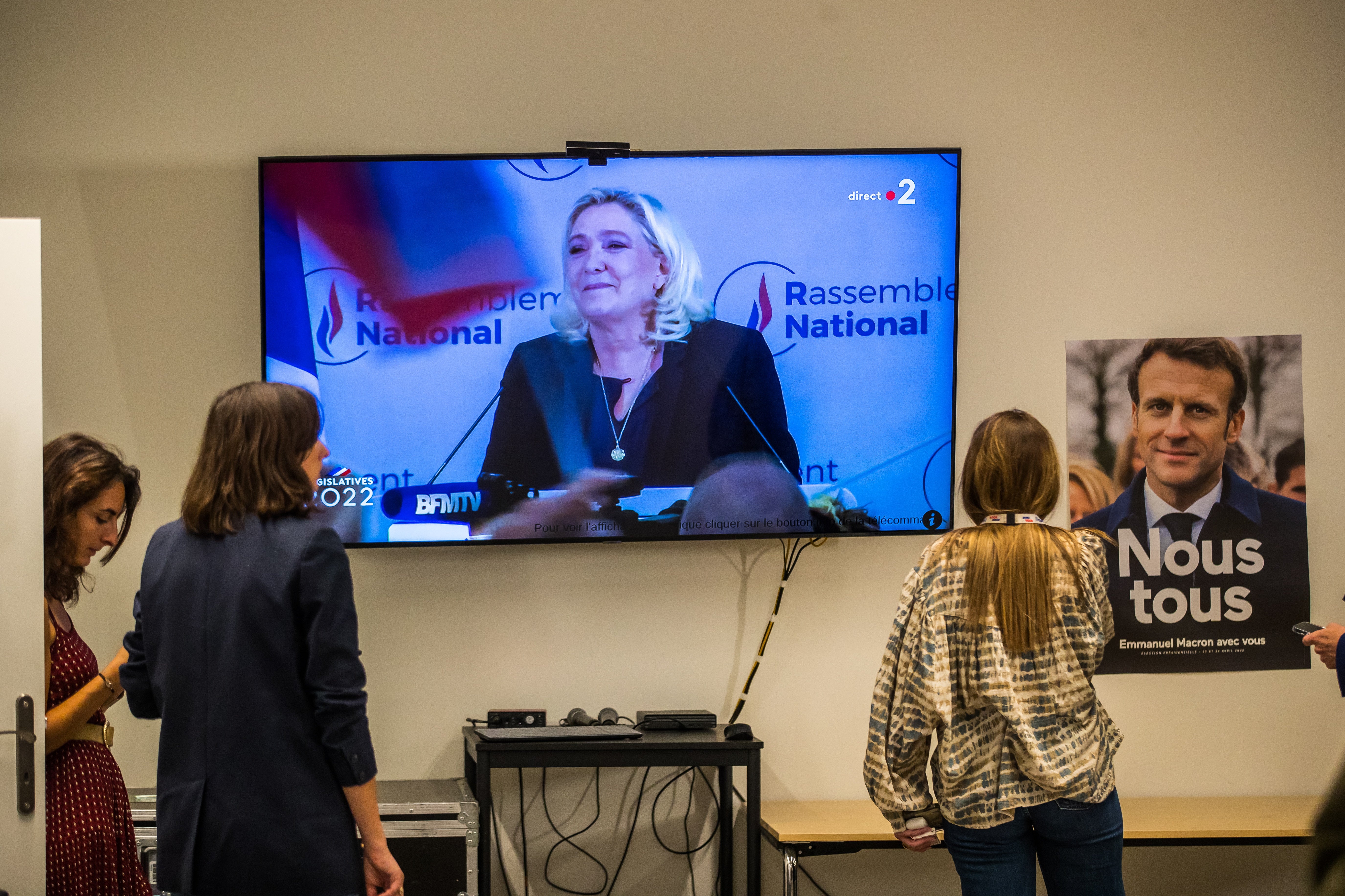 Periodistas y simpatizantes miran a Marine Le Pen pronunciando un discurso en televisión tras los resultados de la segunda vuelta de las elecciones legislativas francesas