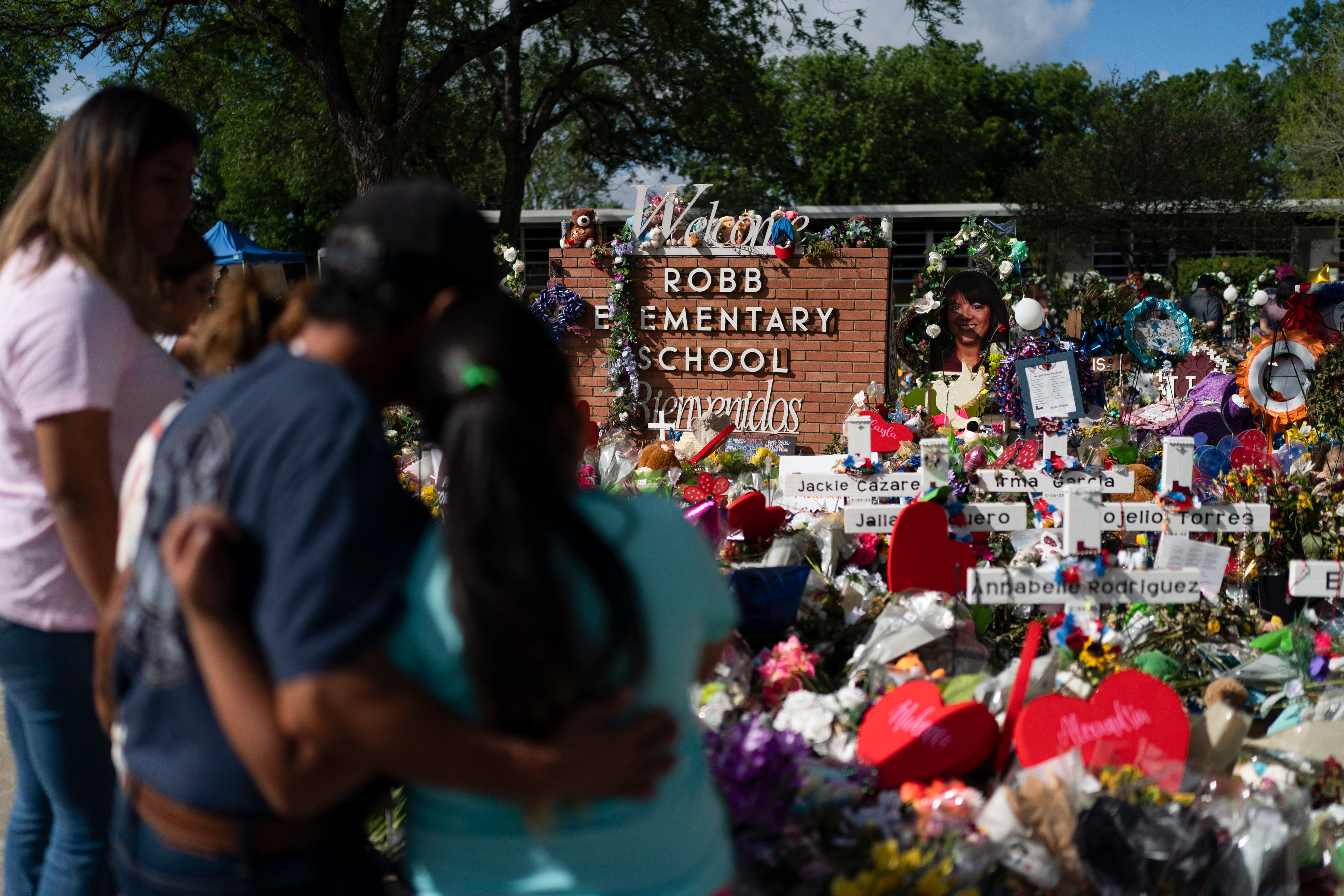 La gente visita el homenaje instalado en la Escuela Primaria Robb, en Uvalde, Texas, el 2 de junio