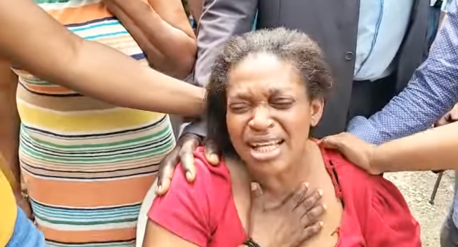 Gwendolyn McKnight es consolada mientras llora el asesinato de su hija y sus cuatro nietos cerca de Kingston, Jamaica, el martes 21 de junio de 2022