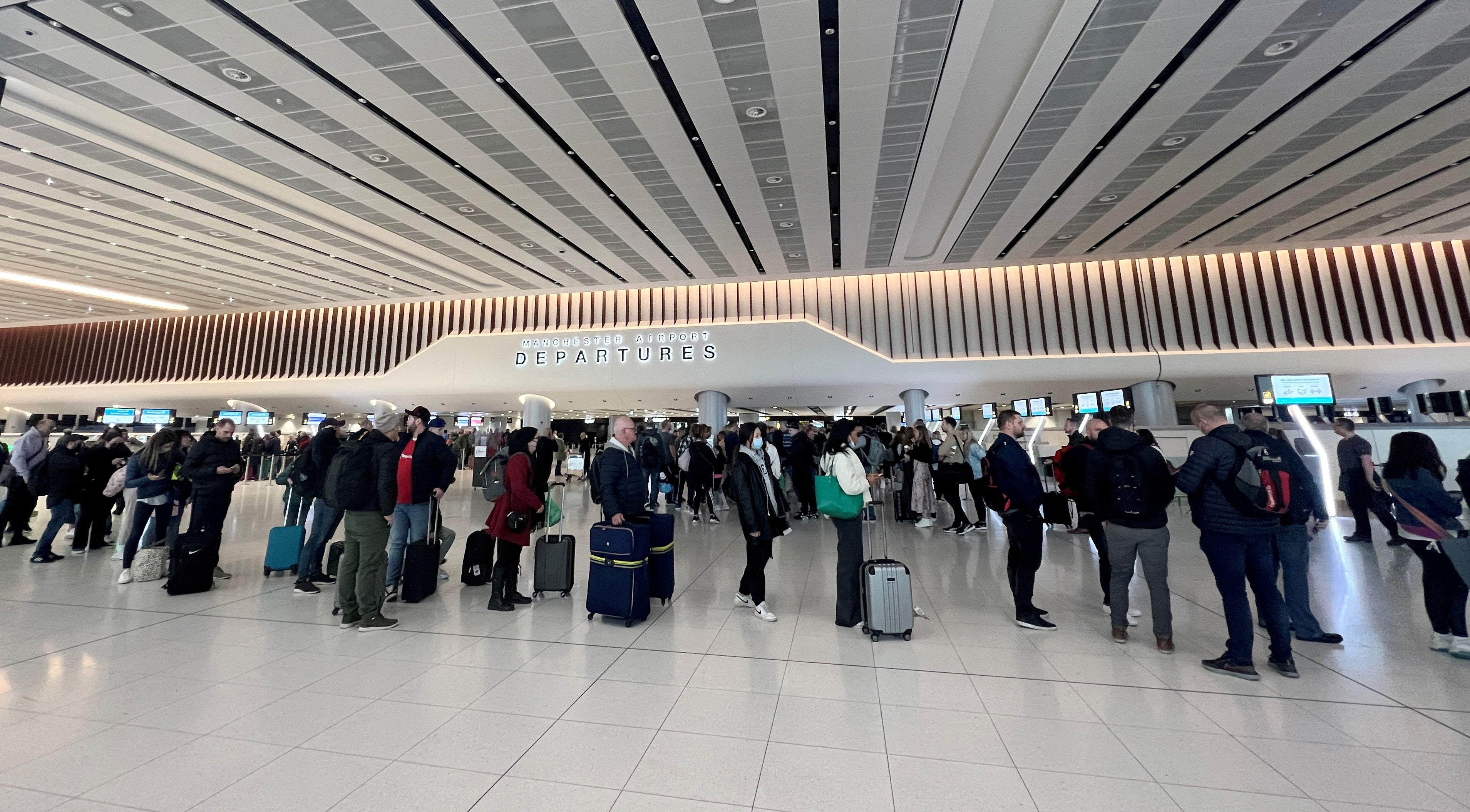 Los pasajeros hacen cola para el control de seguridad en la zona de salidas de la Terminal 2 del aeropuerto de Manchester